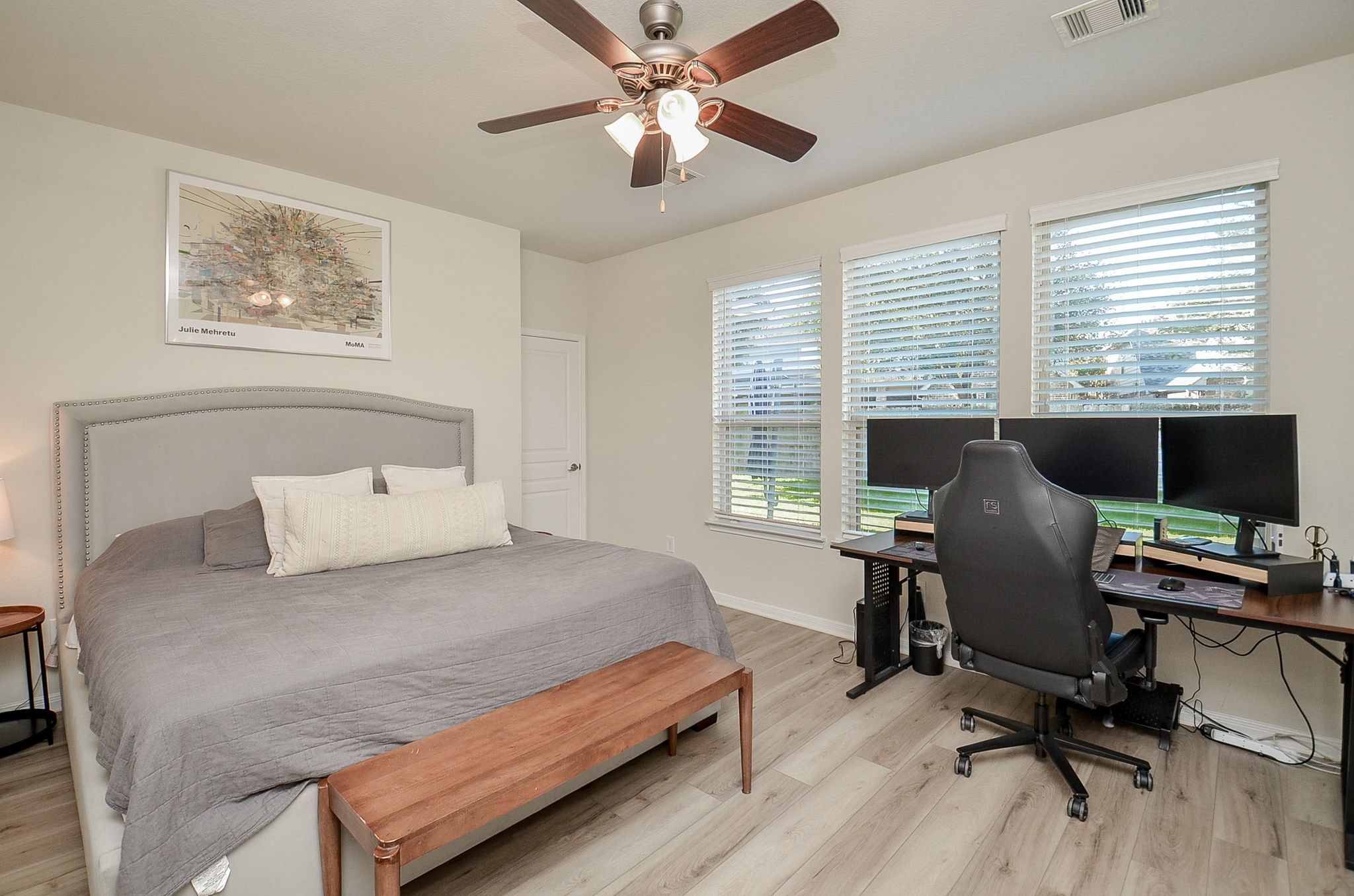 Another view of the primary suite, featuring attractive flooring and generous windows.