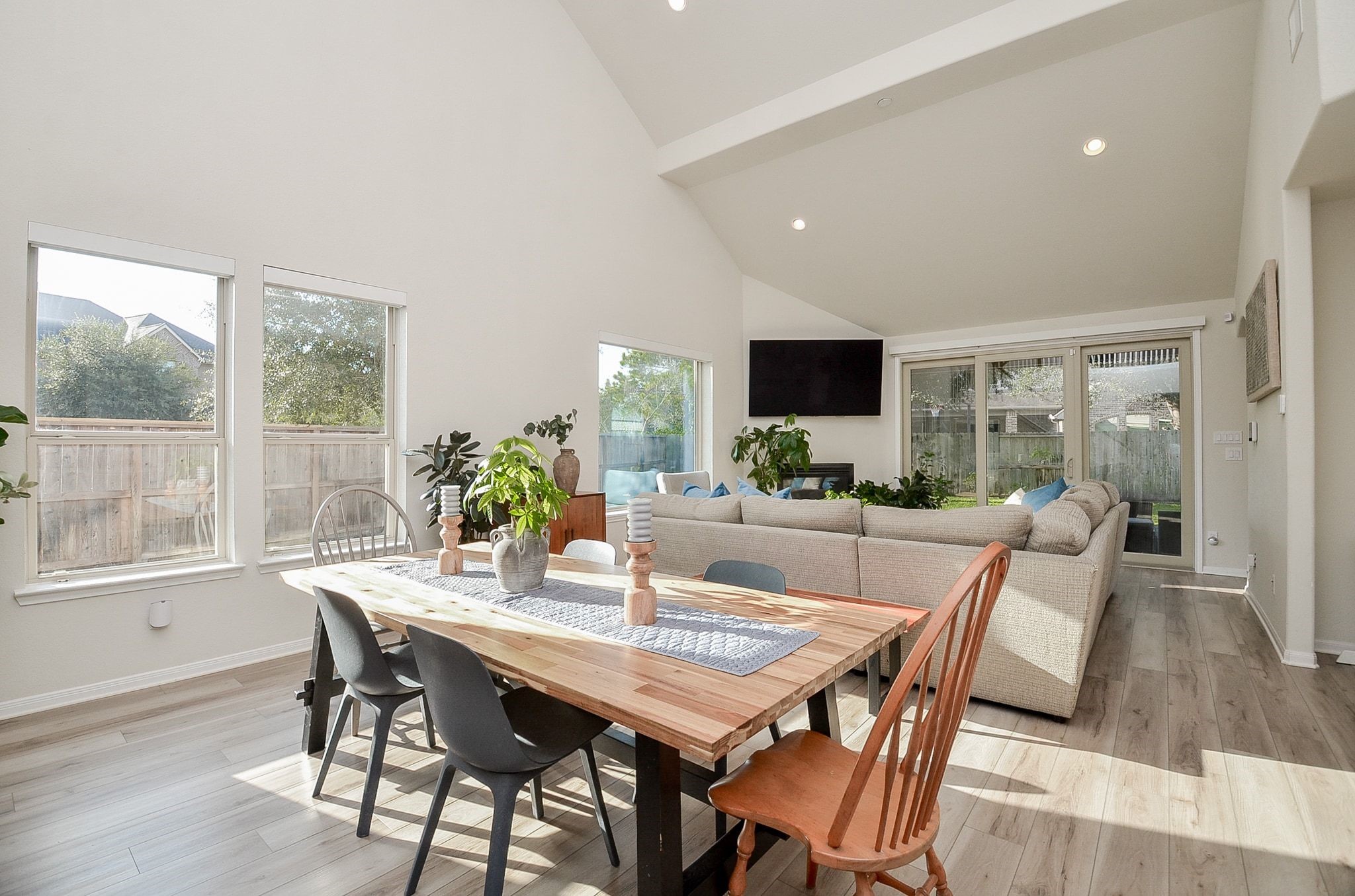 Sun-filled dining and living spaces with high ceilings and updated flooring.