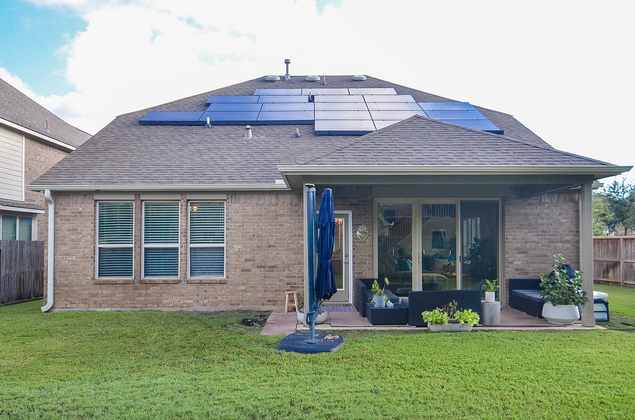 Covered backyard patio and roof-mounted solar panels enhance outdoor living and energy efficiency.