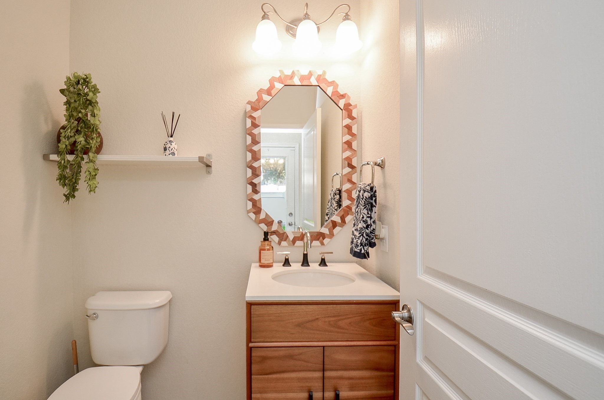 Charming powder room with vanity and decorative mirror.