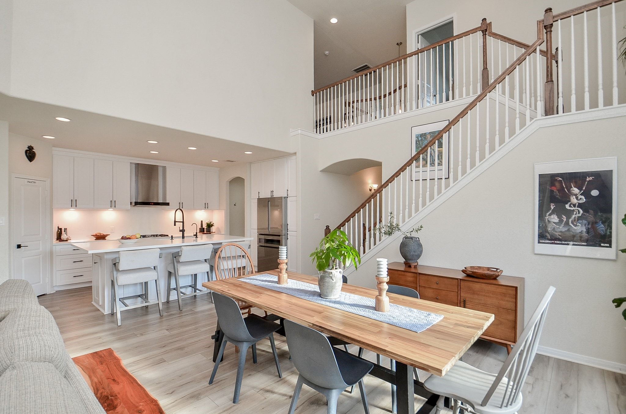 Overview of dining and kitchen with impressive two-story ceilings.