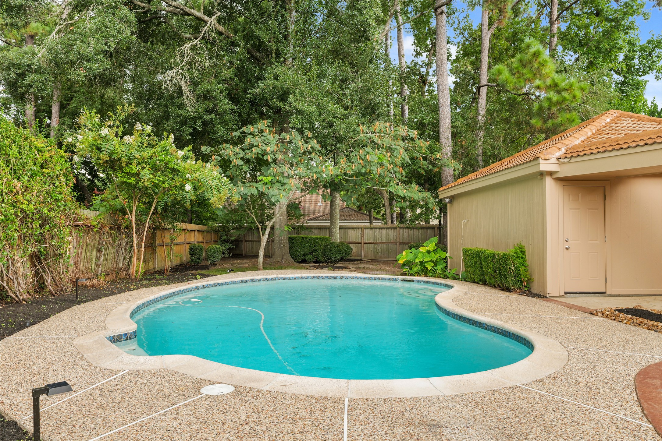 Pool with view of detached garage