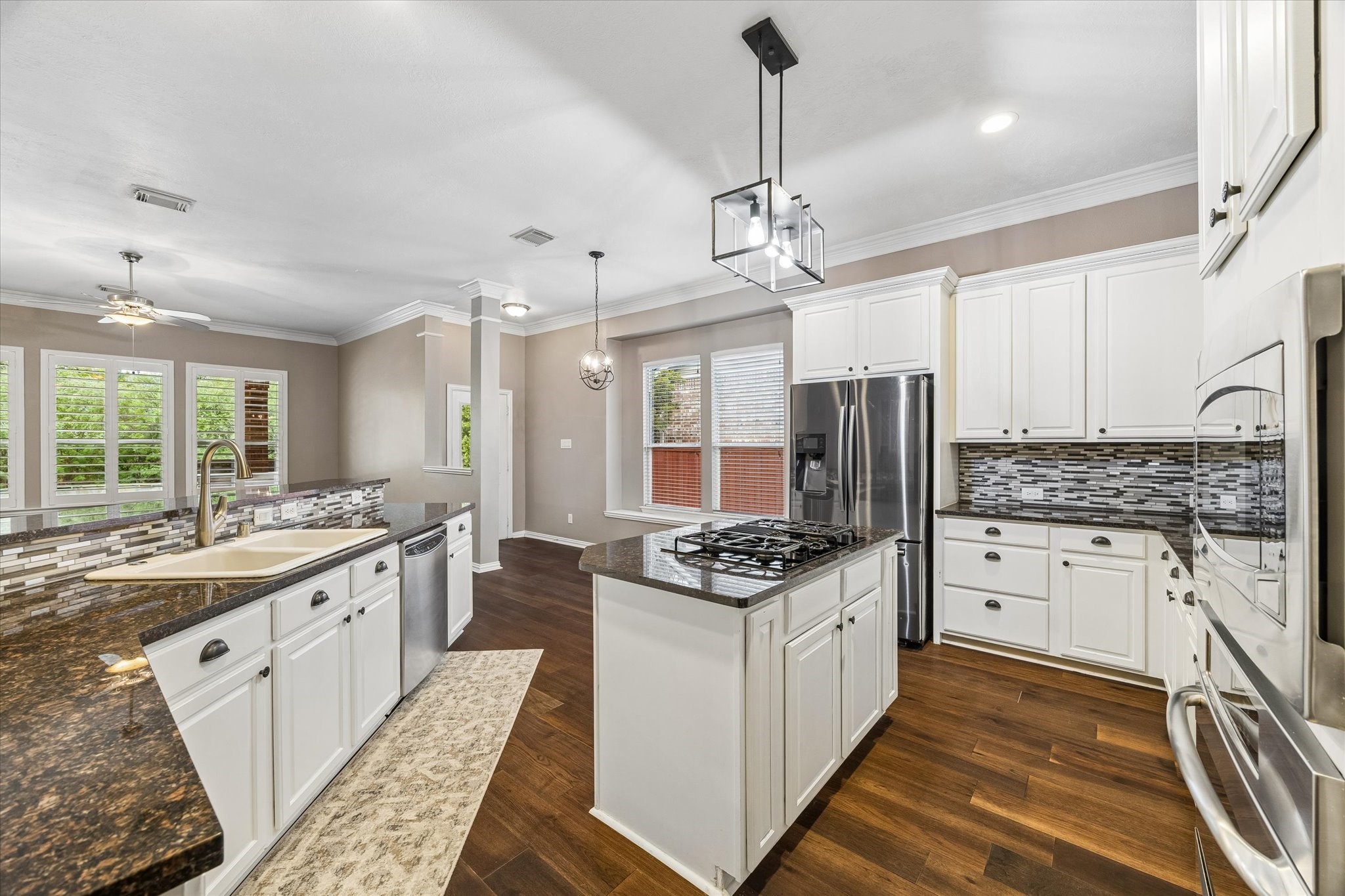 Modern kitchen opens up to living room and view of the pool. Notice the updated lighting fixture Modern kitchen opens up to living room and view of the pool. Notice the updated lighting fixture