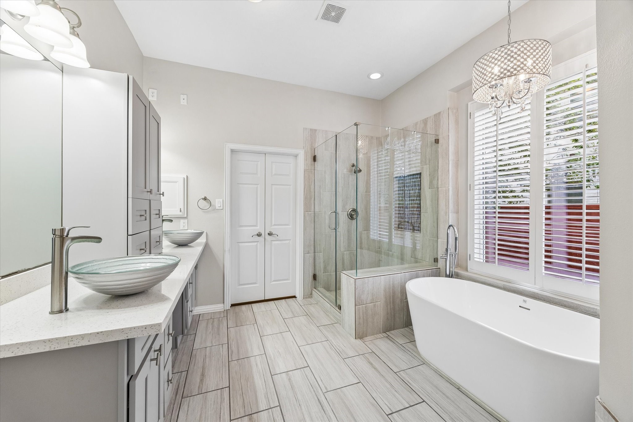 Tastefull all white sleek modern primary bath with walk in closet. Updated lighting fixtures throughout primary bath.
