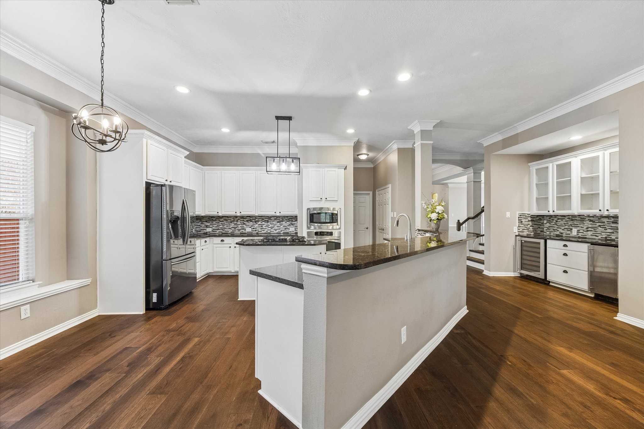 Butler's Pantry and wine fridge and ice maker to the right. Consistent Wood flooring throughout the home Butler's Pantry and wine fridge and ice maker to the right. Consistent Wood flooring throughout the home