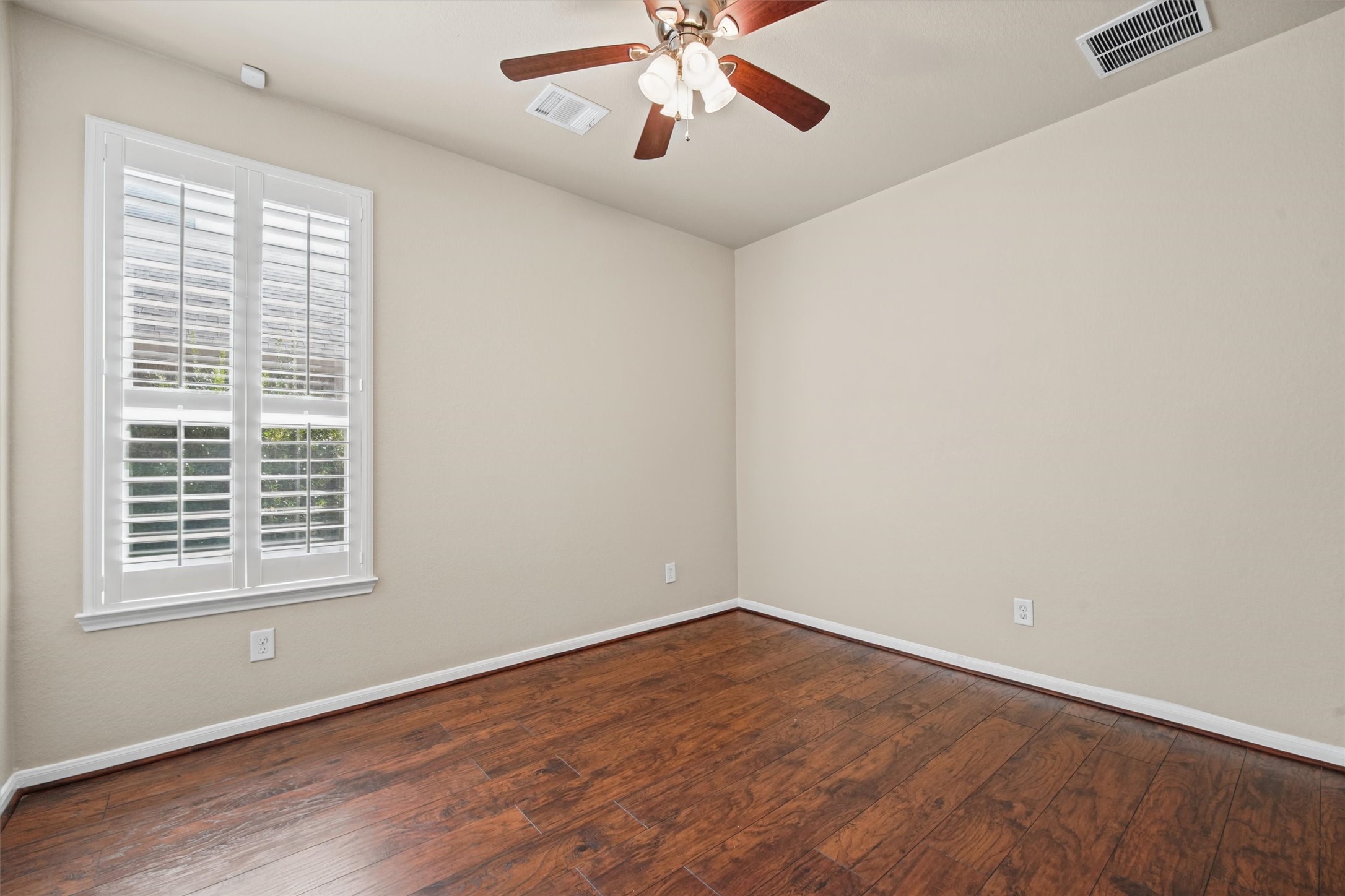 Bedroom 3 with engineered hardwood and plantation shutters.  Could be a perfect study!
