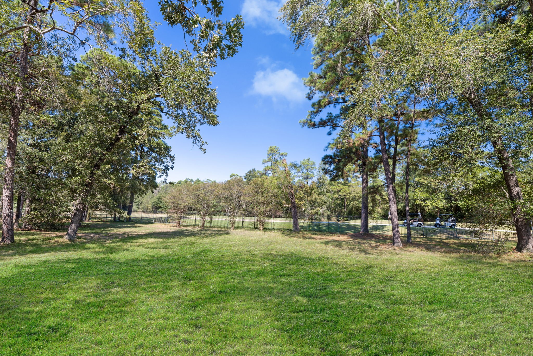View from backyard to the Oaks Golf Course beyond the wrought iron fence.