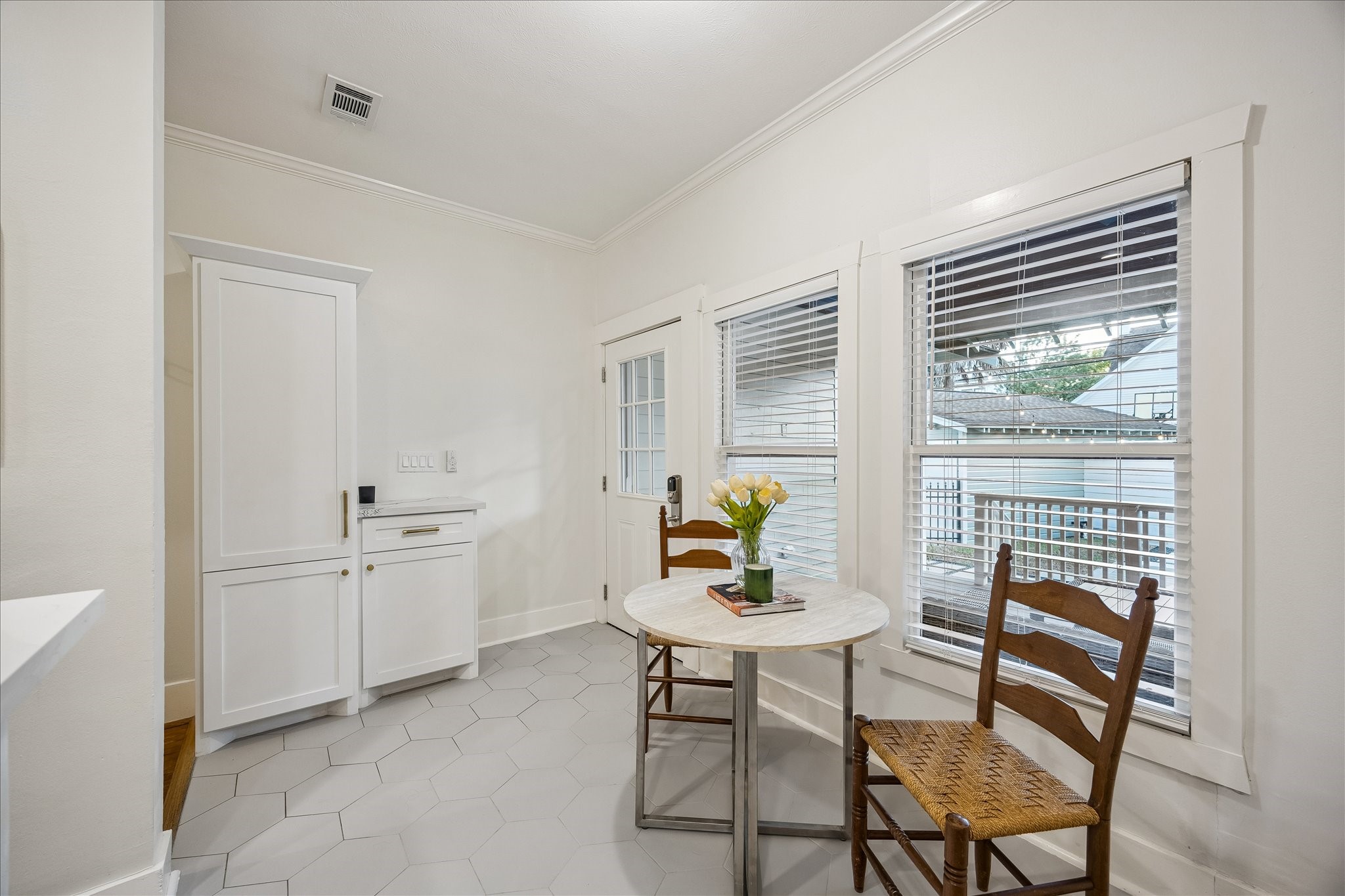The breakfast area with a view to the back door. Thoughtfully placed cabinets serve as the perfect "Landing zone" for all the things after a long work day.
