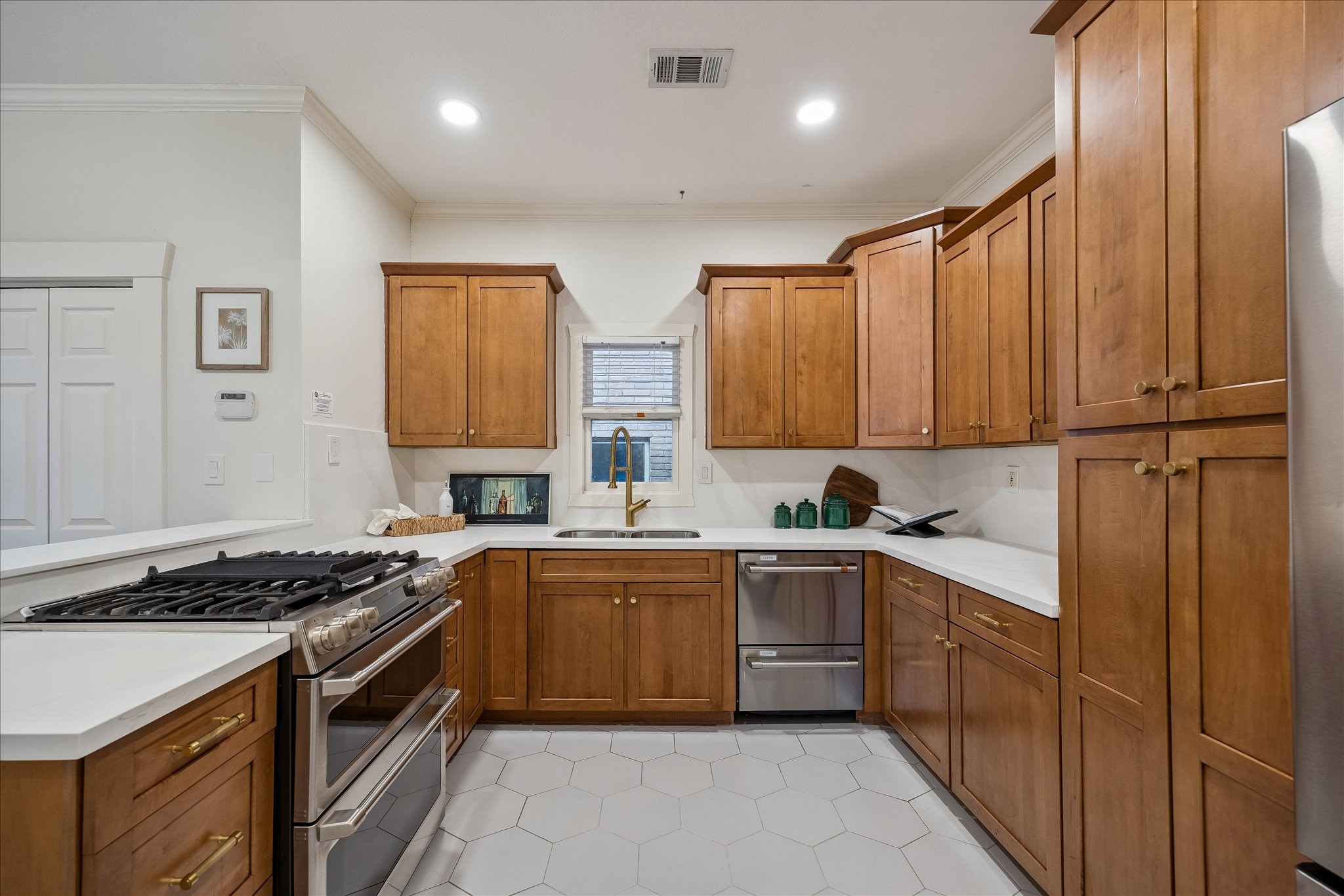 The kitchen with updated hex tile; stainless steel appliances; breakfast bar; and abundant cabinet space.
