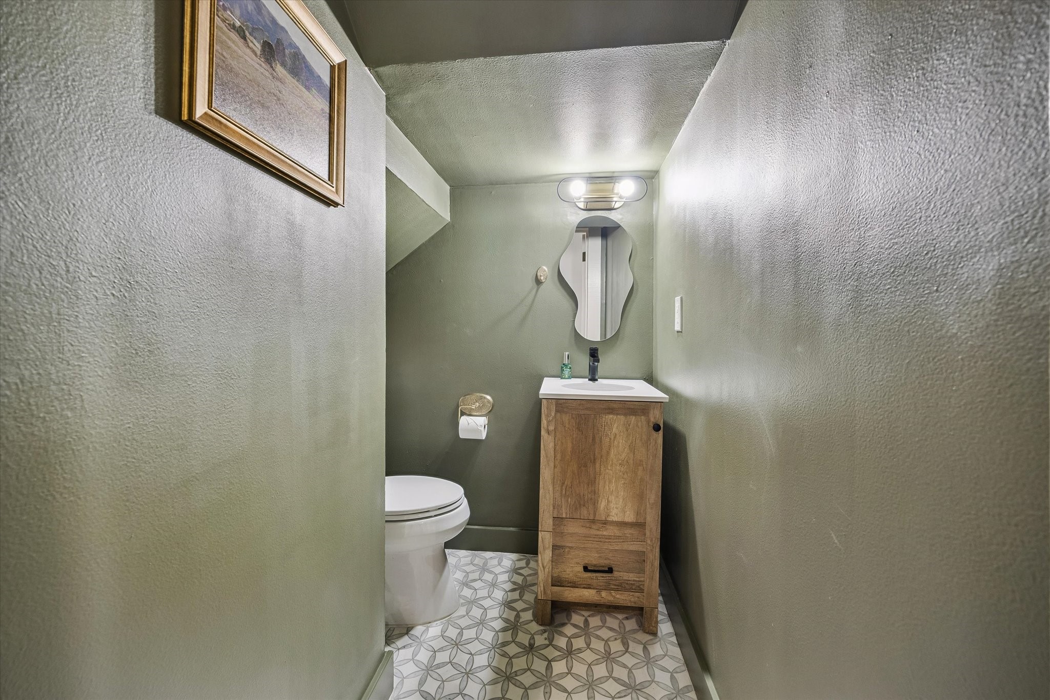 Tucked under the stairs is the powder bath.