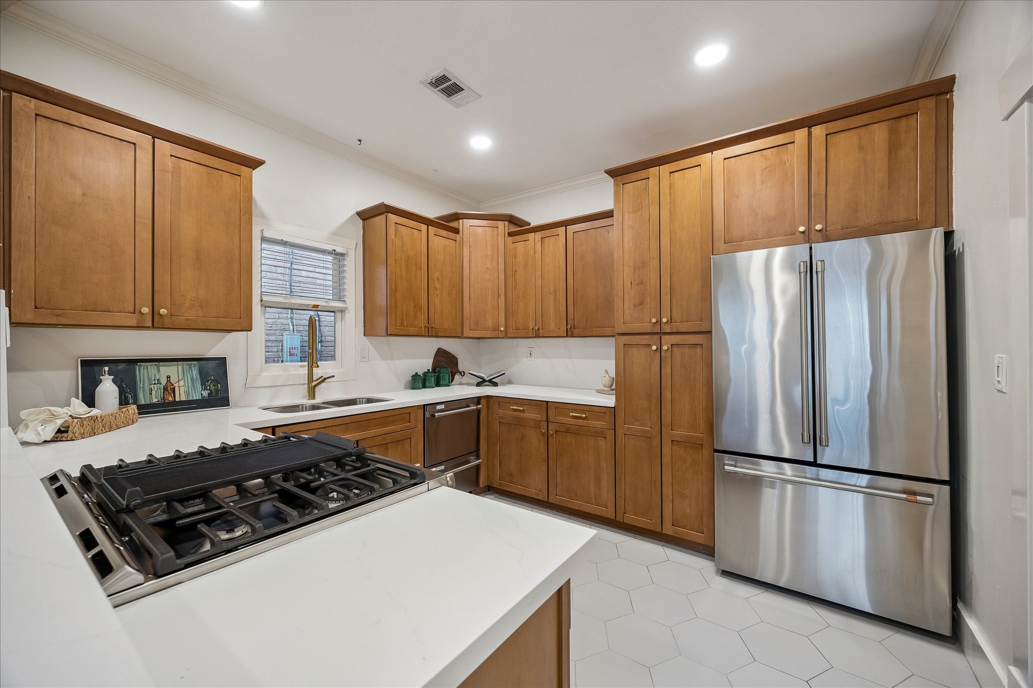 The gas cook top features downdraft ventilation. Refrigerator can convey with the house.