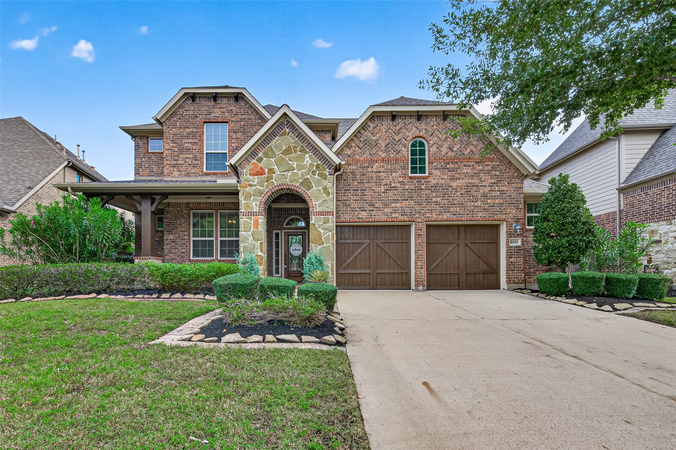 Two-story brick and stone front elevation, straight-on view