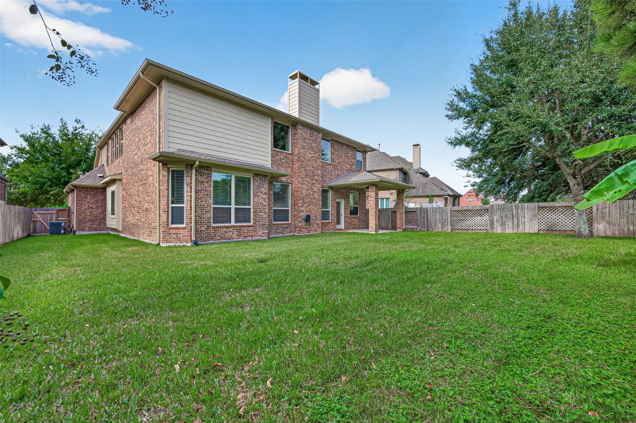 Large lawn with brick fence and sprinklers, room for outdoor living