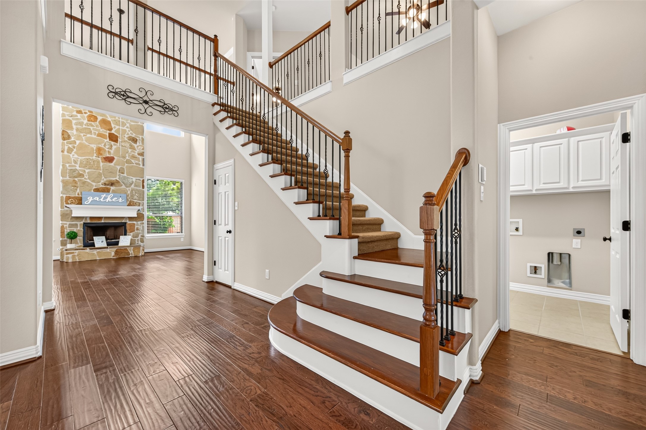Grand entry with staircase, engineered wood floors and view to the family room