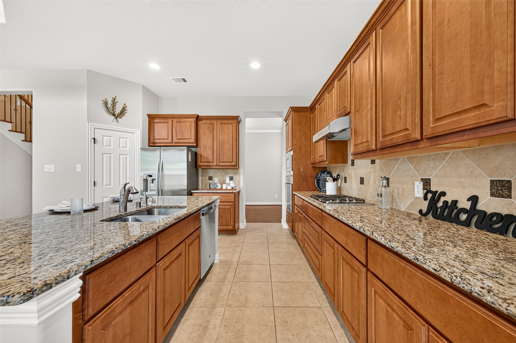 Granite counters and warm wood cabinets with plenty of working space