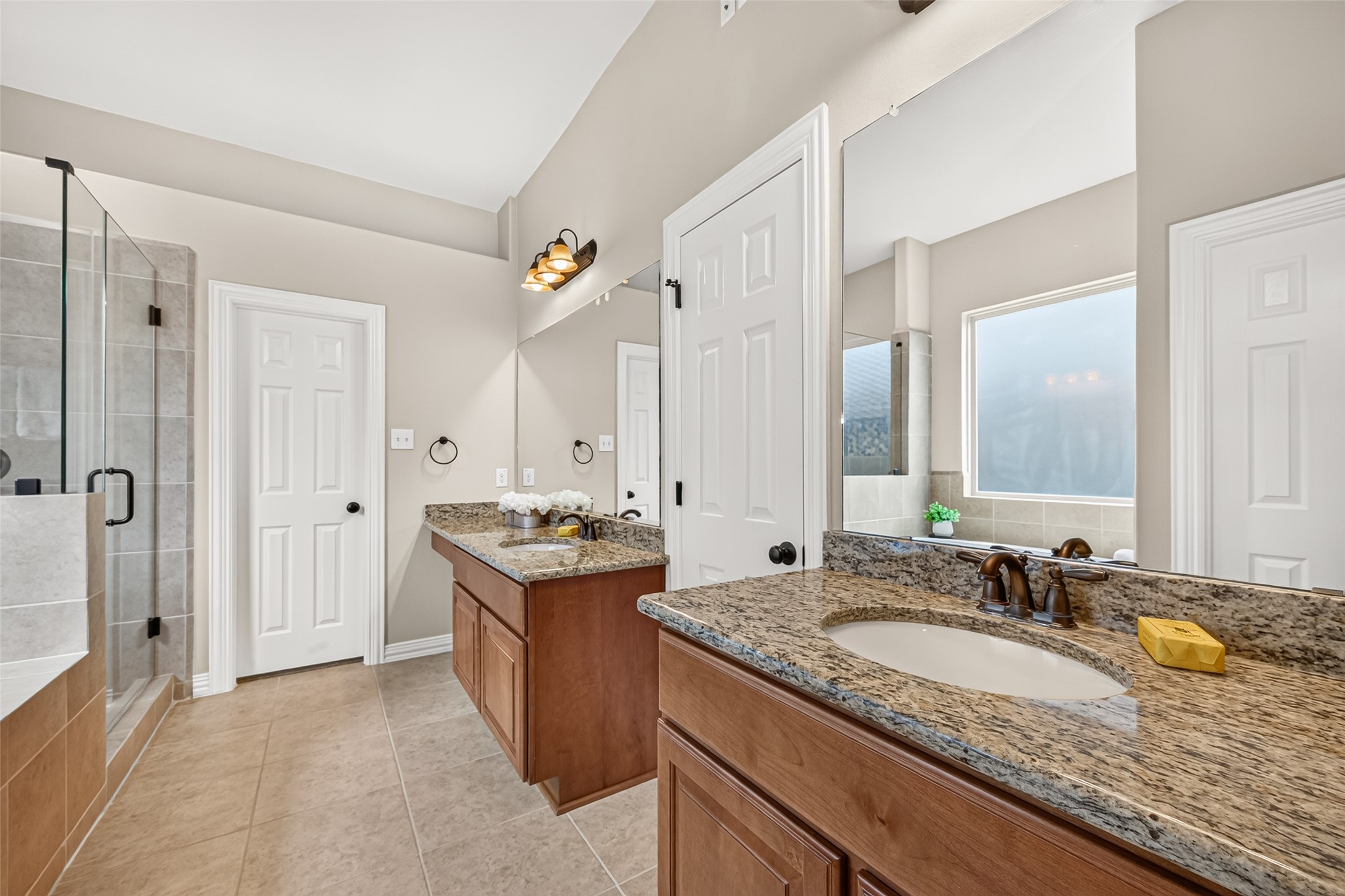 Updated primary bathroom with separate his and hers walk-in closets