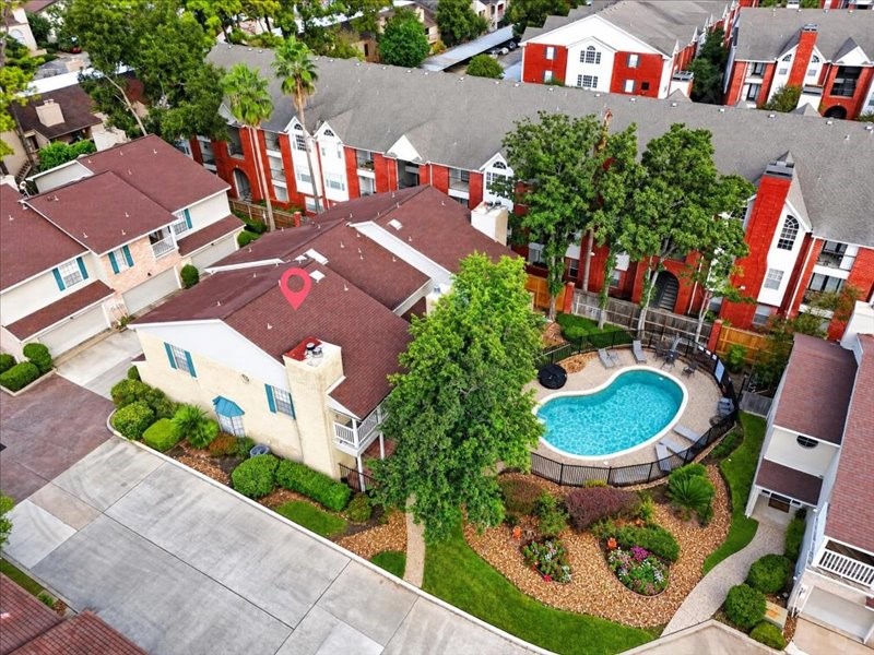 Aerial view of Bering Oaks, showing the homes location near the community pool, mature trees, and landscaped grounds. Location marker is approximate.