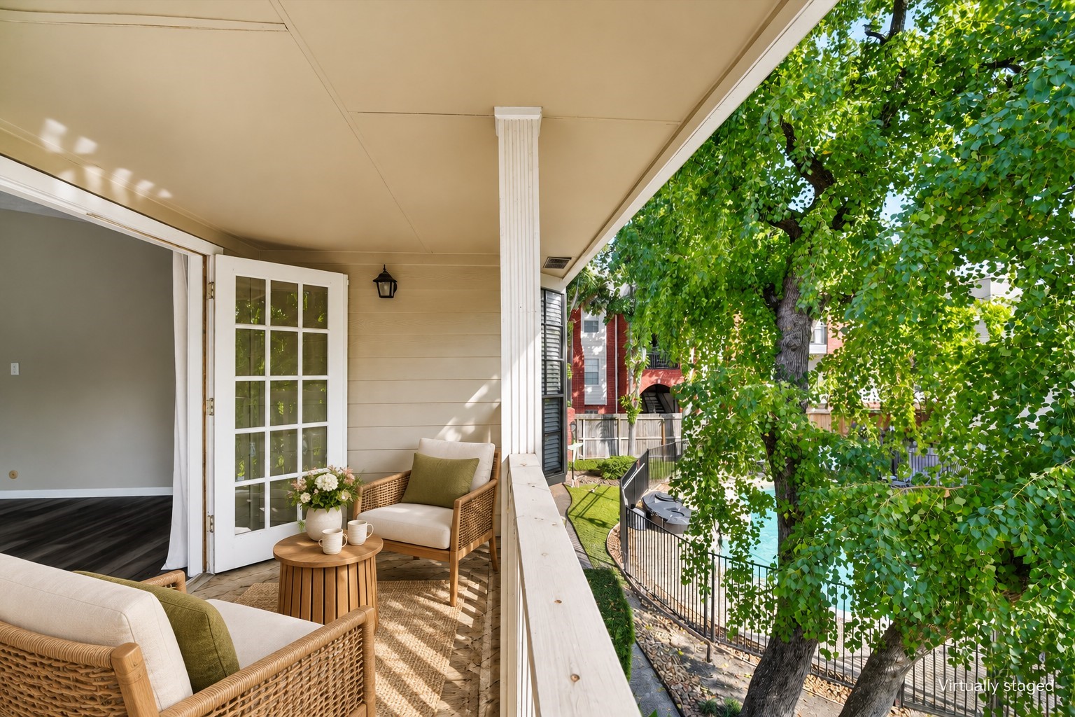 Covered balcony off the primary suite, overlooking mature trees and the community poola relaxing retreat for morning coffee or unwinding outdoors. Virtually staged.