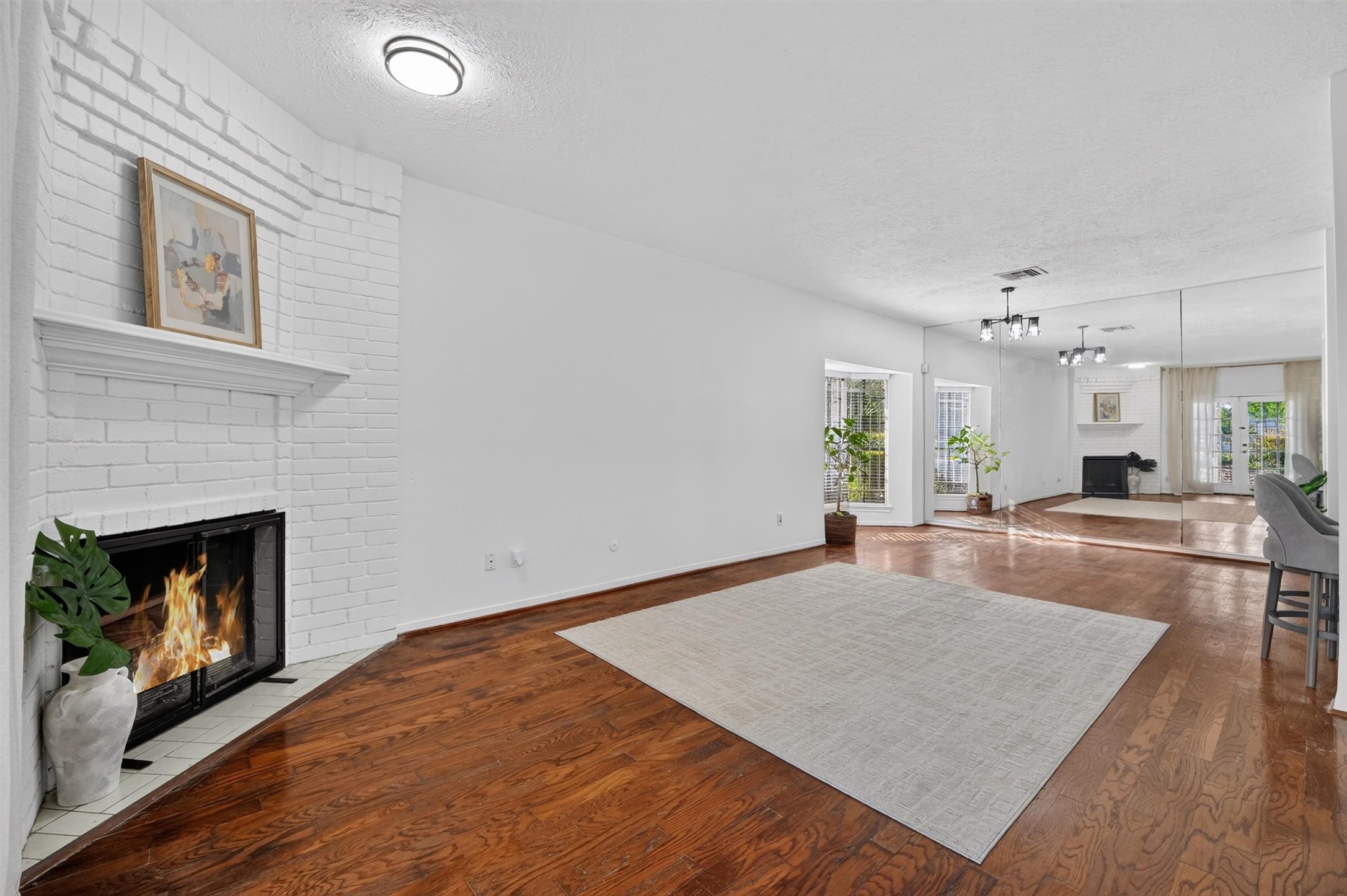 Unstaged living room showing the fireplace, flooring, and open connection to the dining area.