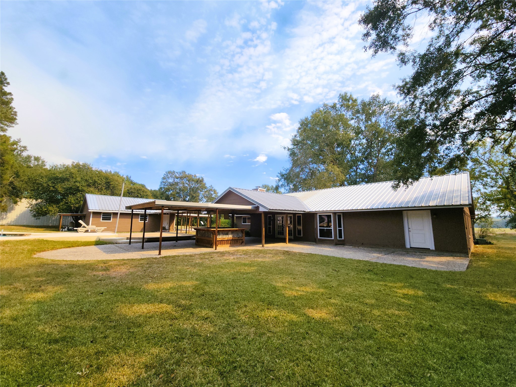 Closer look at the back of the house with the covered outdoor bar overlooking the pool.