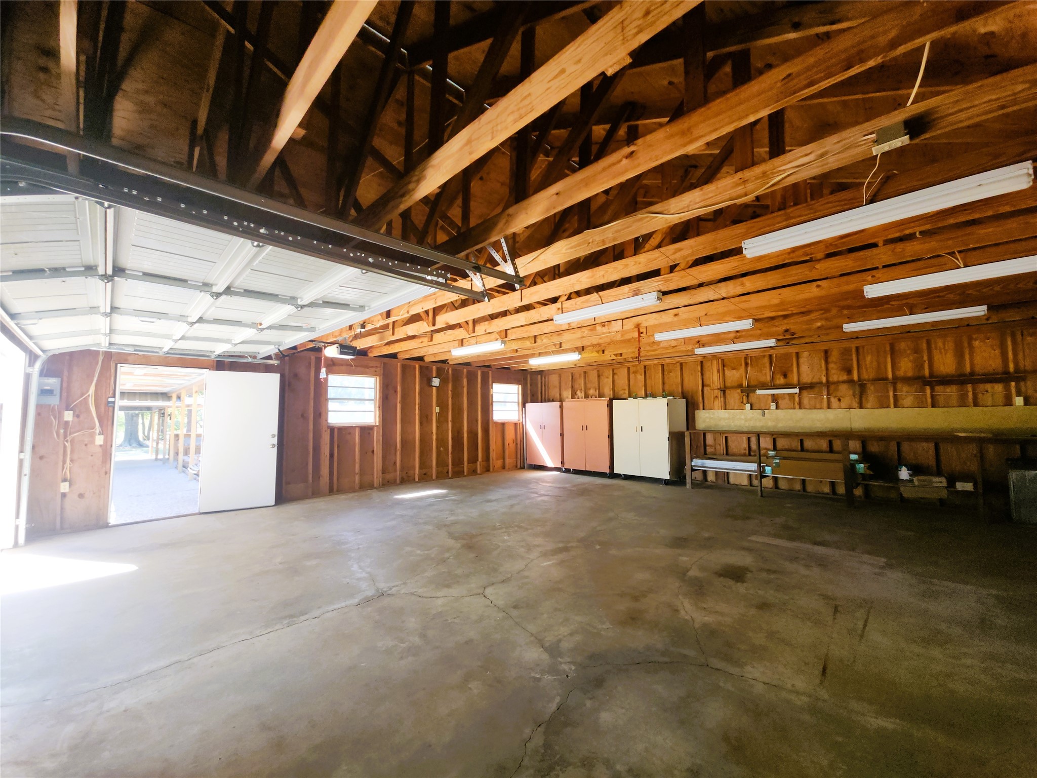 Spacious 30'x30' detached garage with high ceilings, ample natural light, and plenty of room for storage or workshop activities.