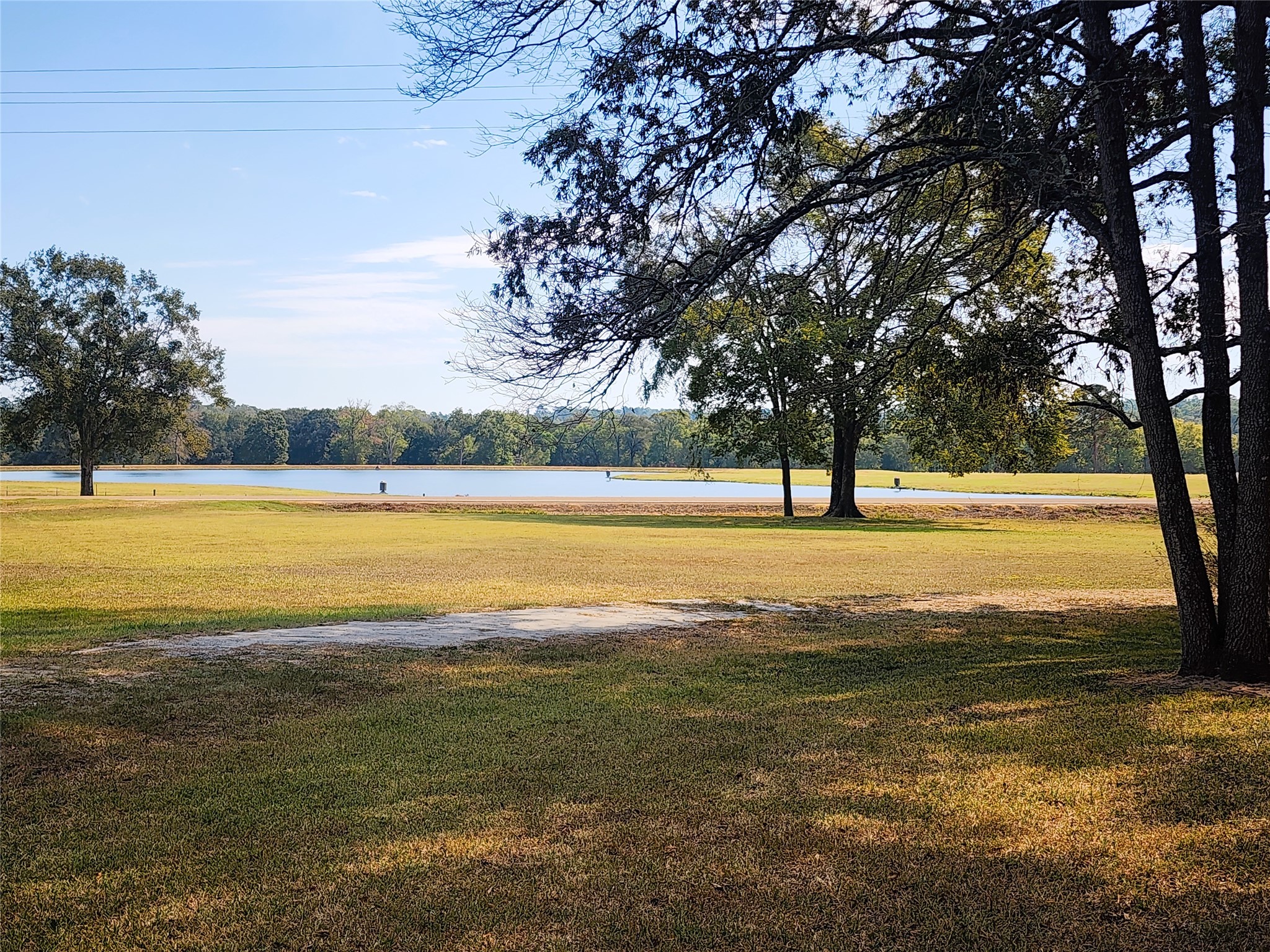 Enjoy serene lake views across the street from this spacious, tree-lined property, perfect for outdoor relaxation and scenic beauty.
