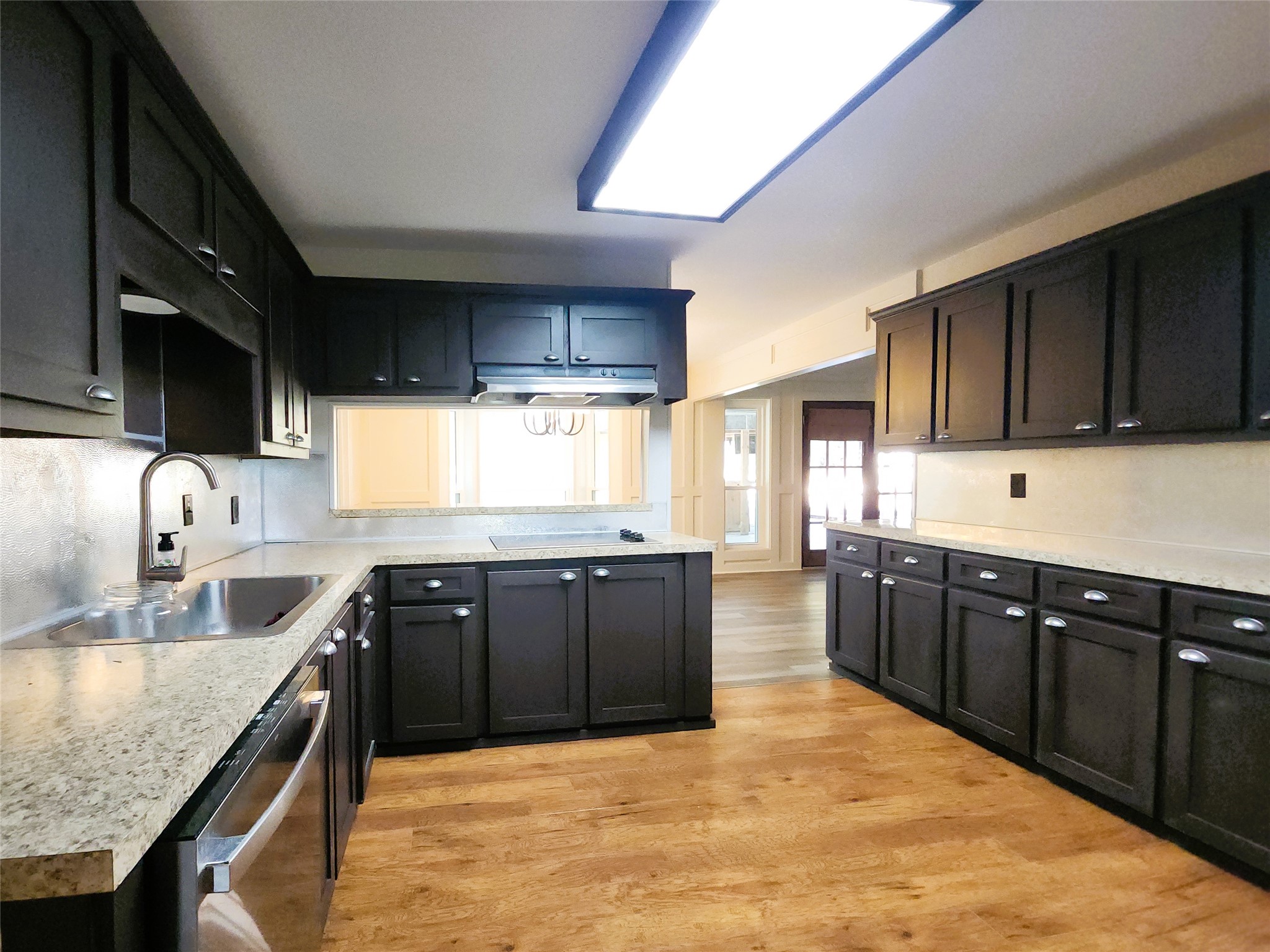 Spacious kitchen with elegant dark cabinetry, stainless steel appliances, corner pantry and breakfast bar. Spacious kitchen with elegant dark cabinetry, stainless steel appliances, corner pantry and breakfast bar.