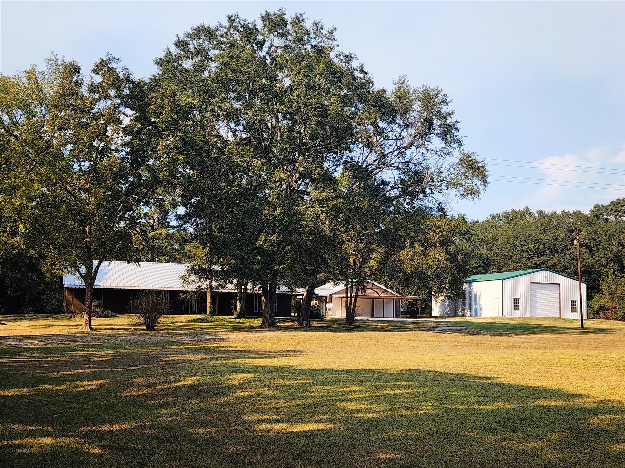 Welcome to 557 FM 2693 East.  A 5.89-acre property featuring a charming home nestled among mature trees, with a spacious lawn, pool and multiple outbuildings.