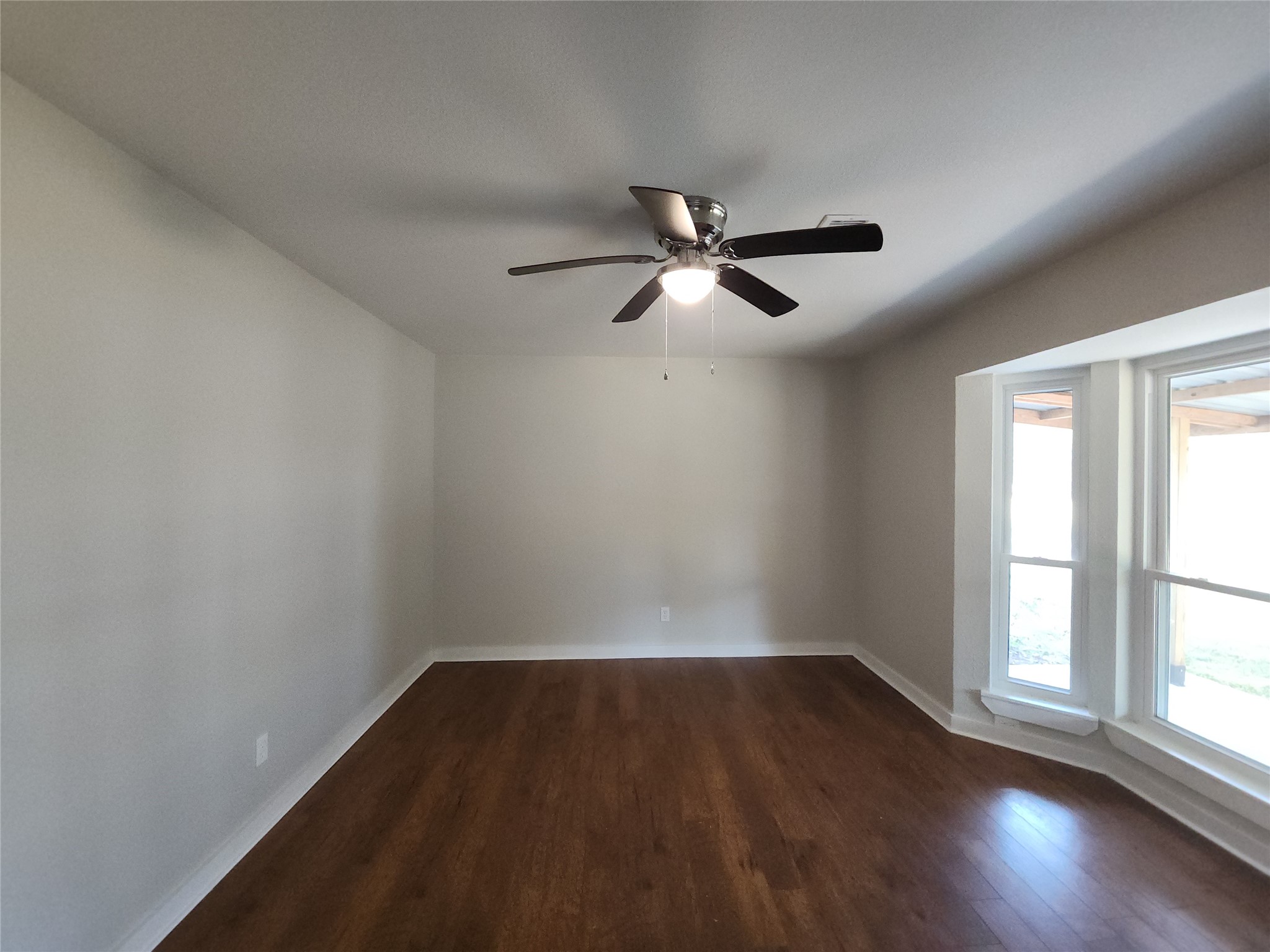 Spacious room featuring abundant natural light from large bay windows.