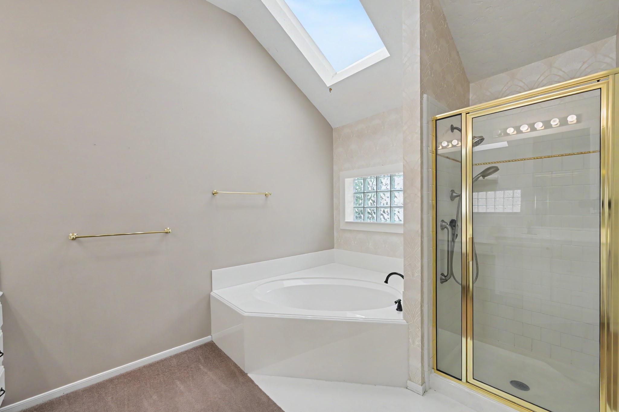 Primary En-Suite soaking tub, stand-alone shower, and skylight for natural light.
