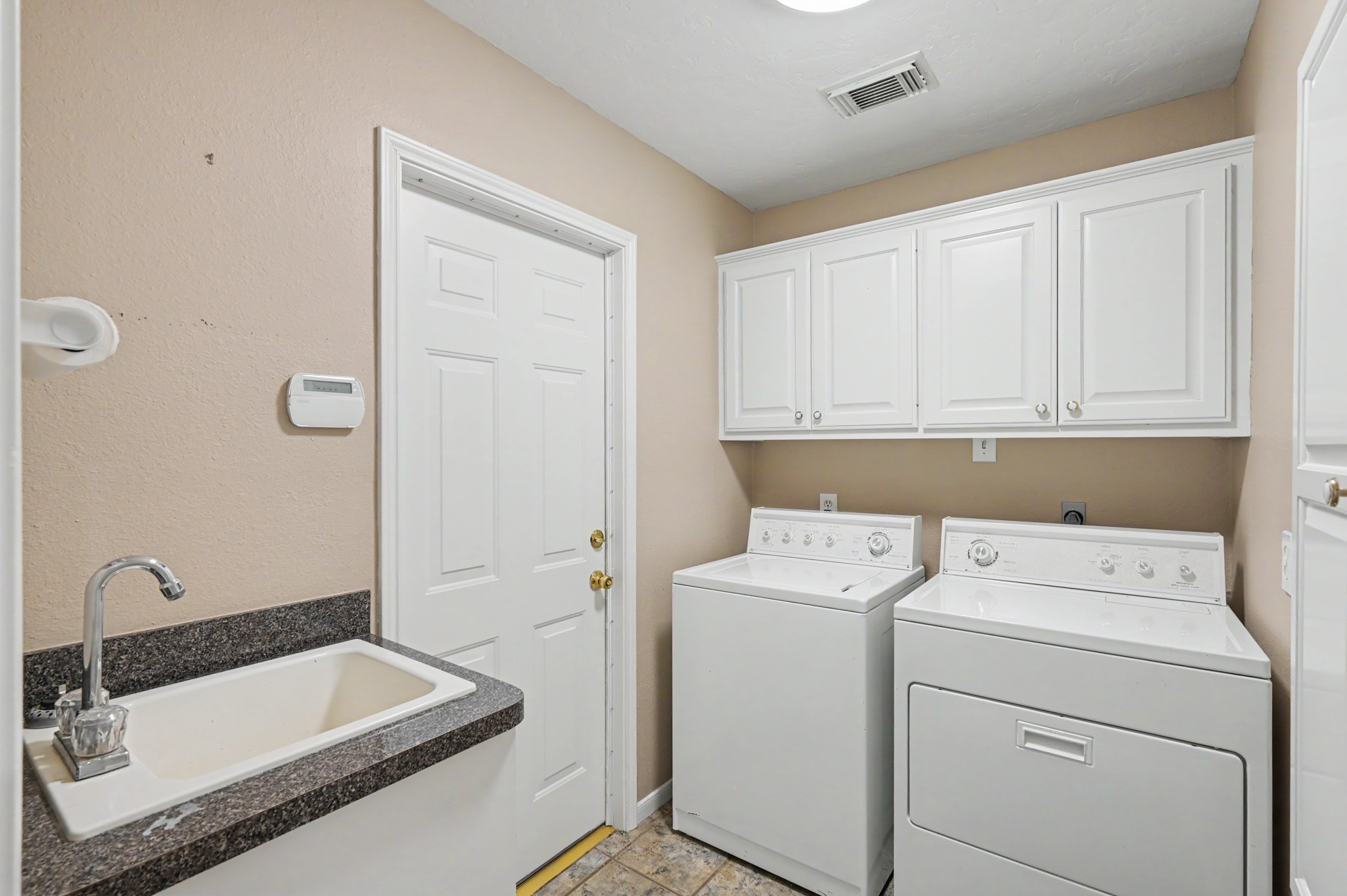 Utility Room with Utility Sink, door leads to garage.