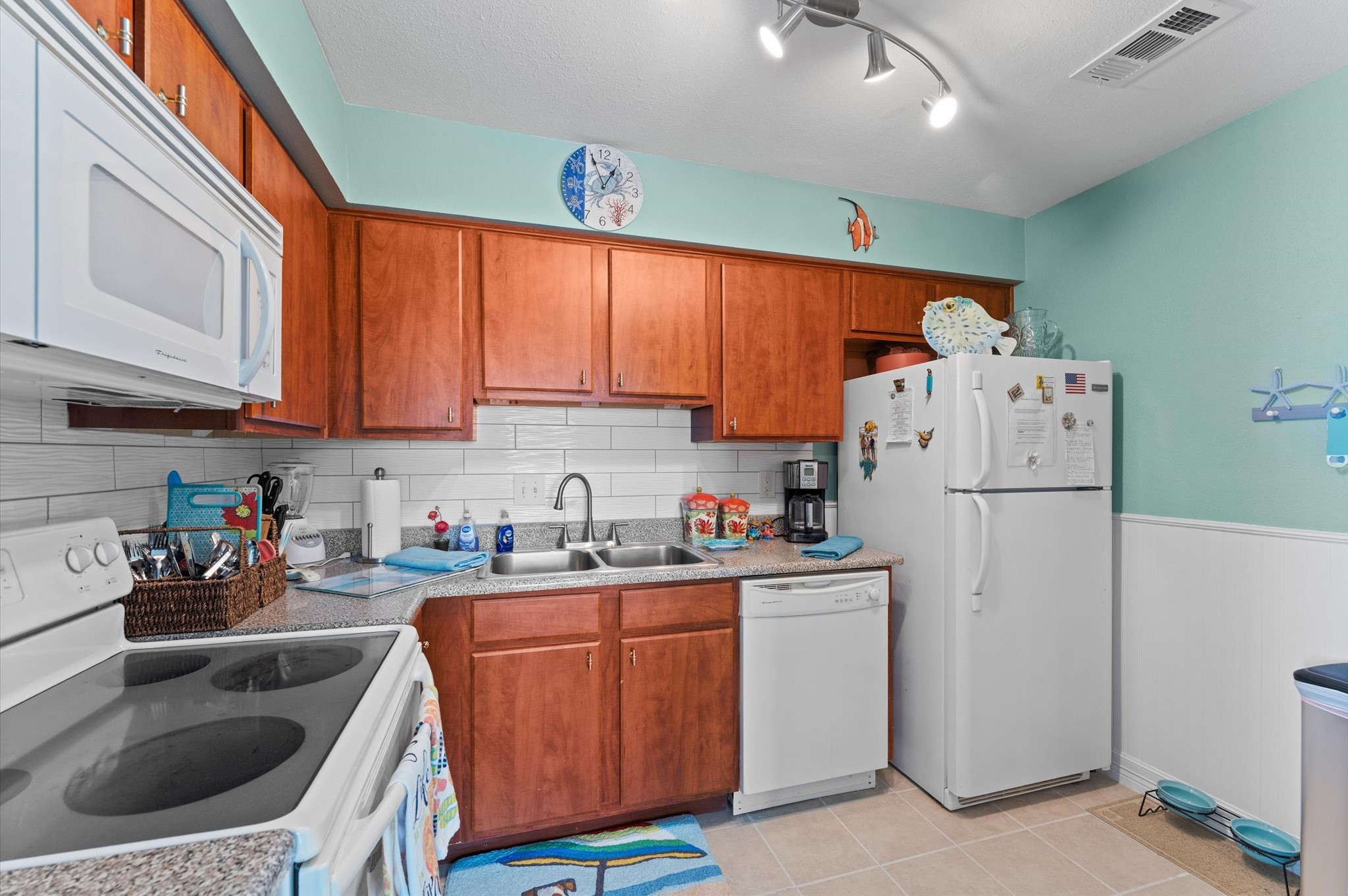 The kitchen is both inviting and well-designed with classic enhancements including a sleek backsplash and shiplap detailing!