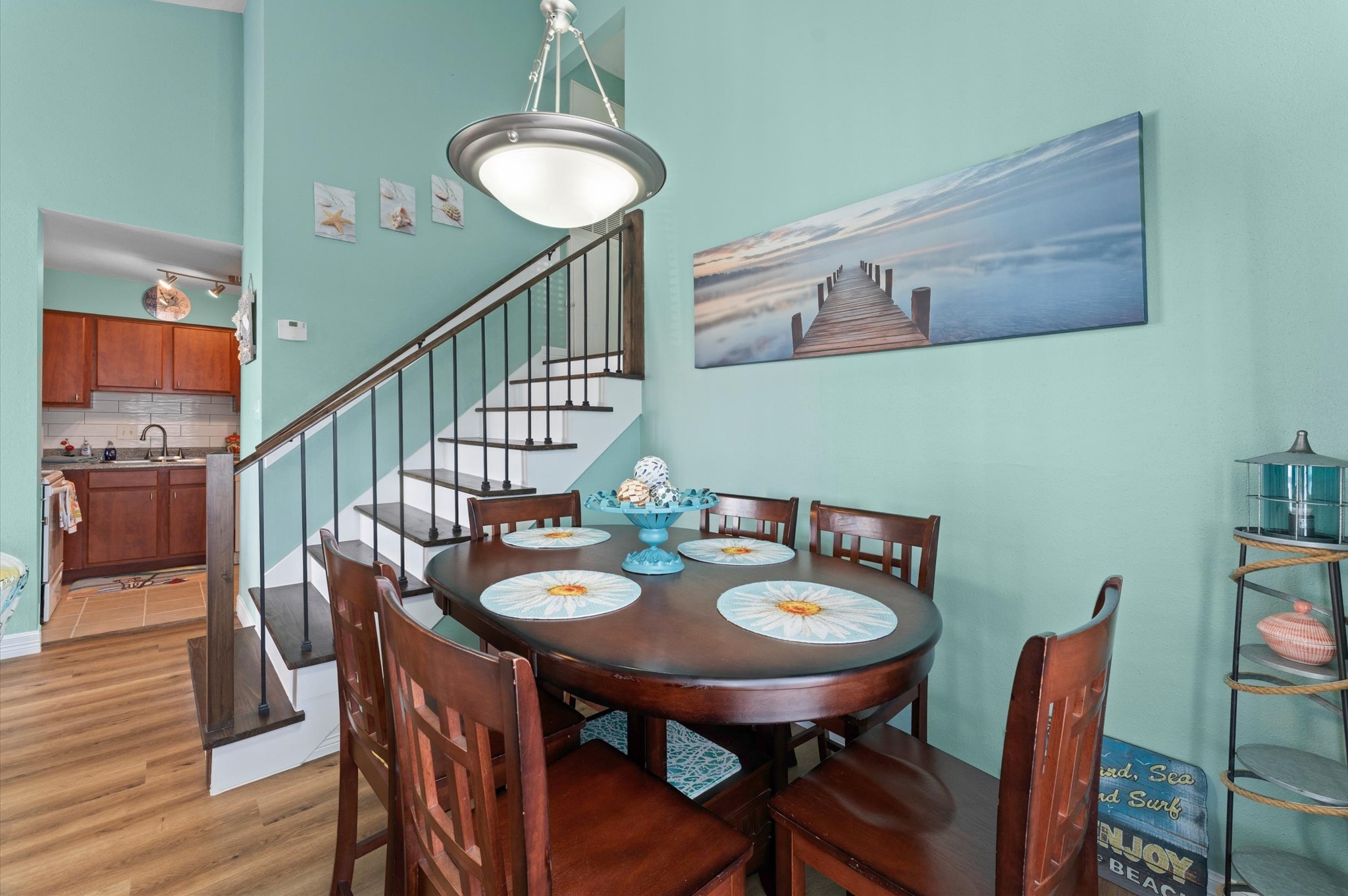 This home features new (2026) LVP flooring, and the stairs shown here were updated with solid treads and wrought-iron railing. Tastefully decorated throughout.