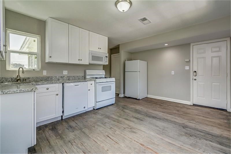 Bright white cabinetry and modern appliances create a clean, contemporary kitchen.