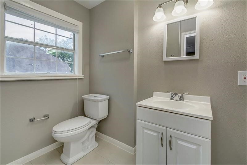 Bathroom featuring a modern vanity, sleek fixtures, and a large window for natural light.