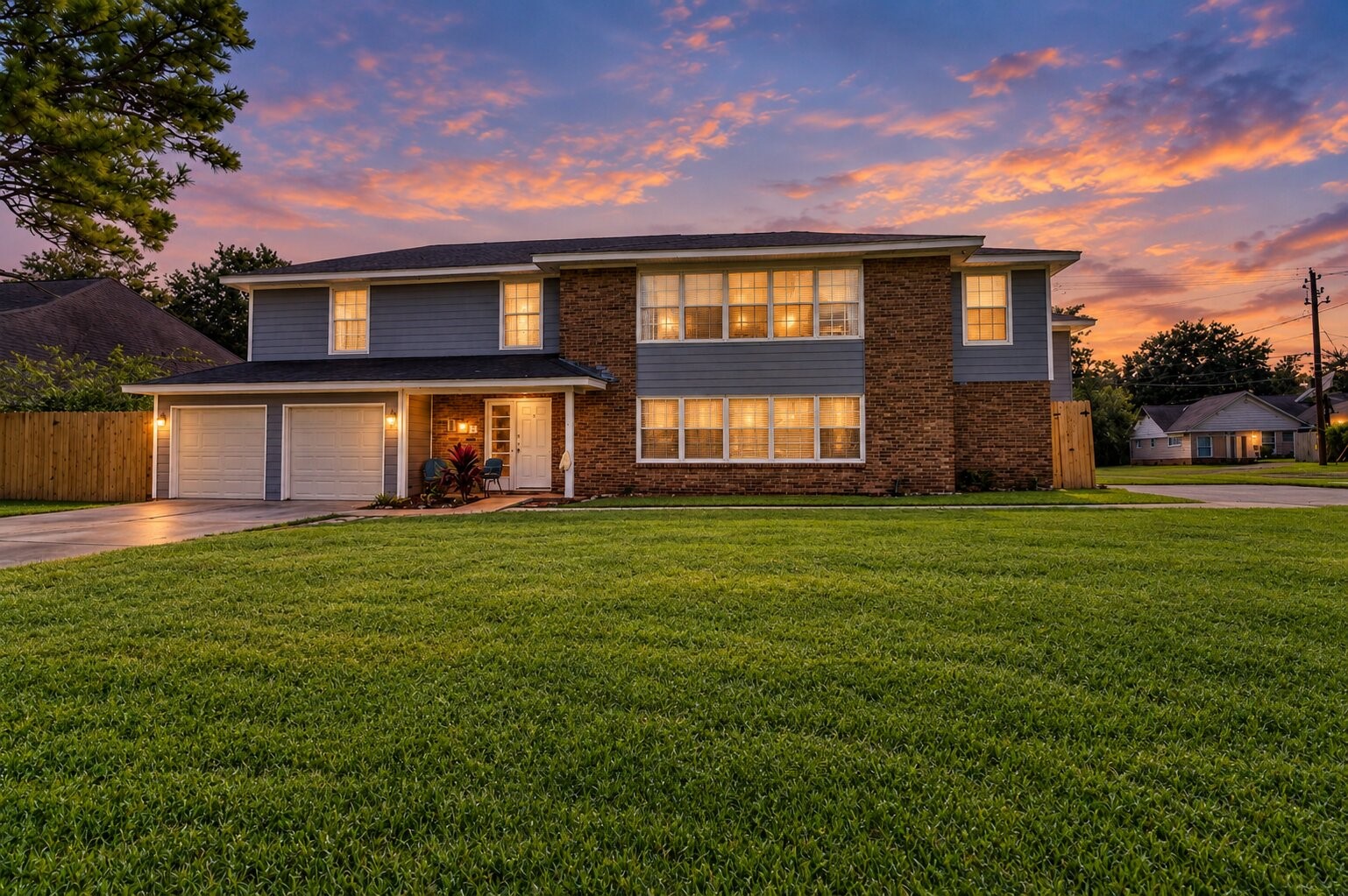 Two-story home with a blend of brick and siding, featuring a double garage and a well-maintained front lawn, perfect for family living.