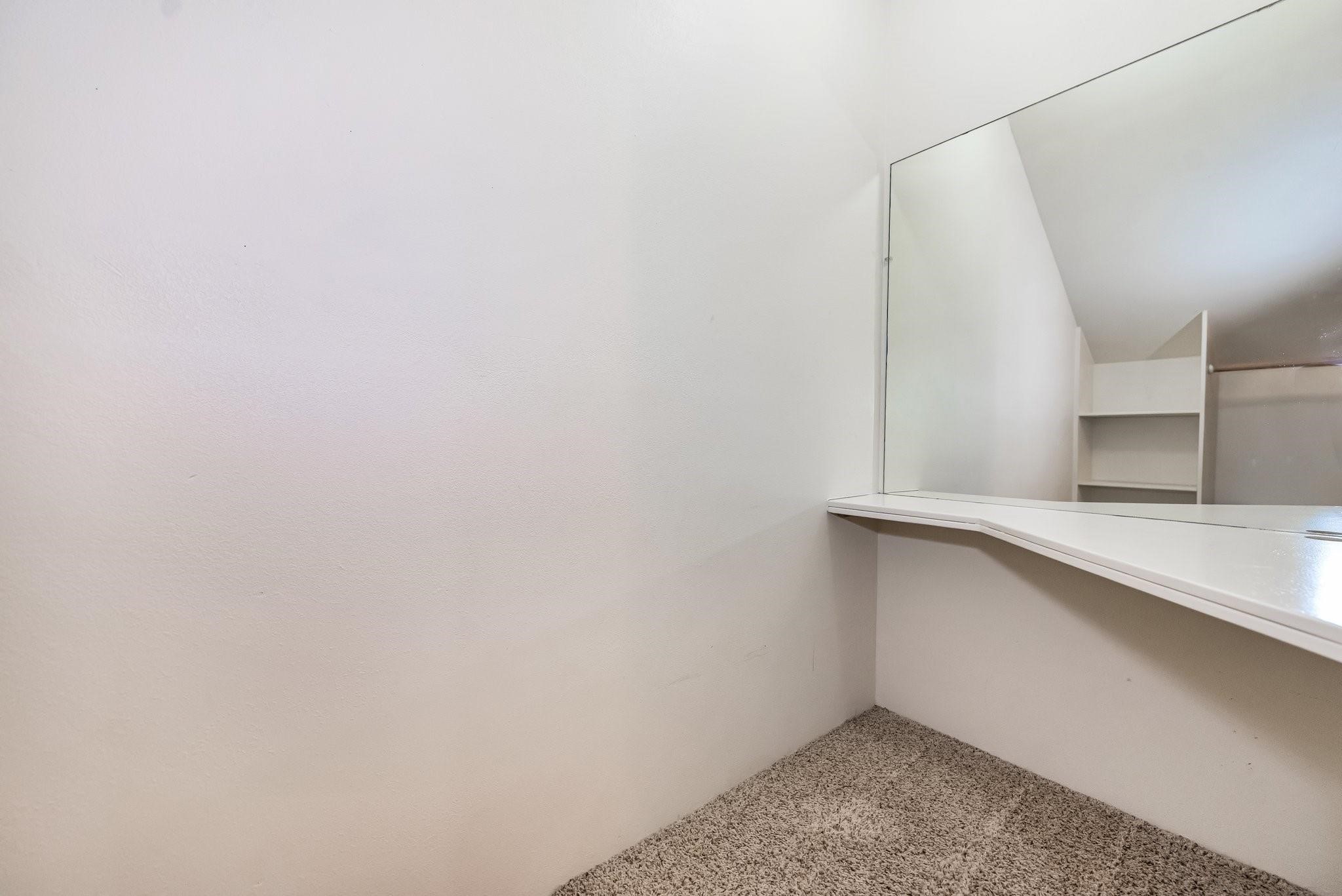 Third bedroom closet with built-in desk that could be used as a study space or a princess dressing area.