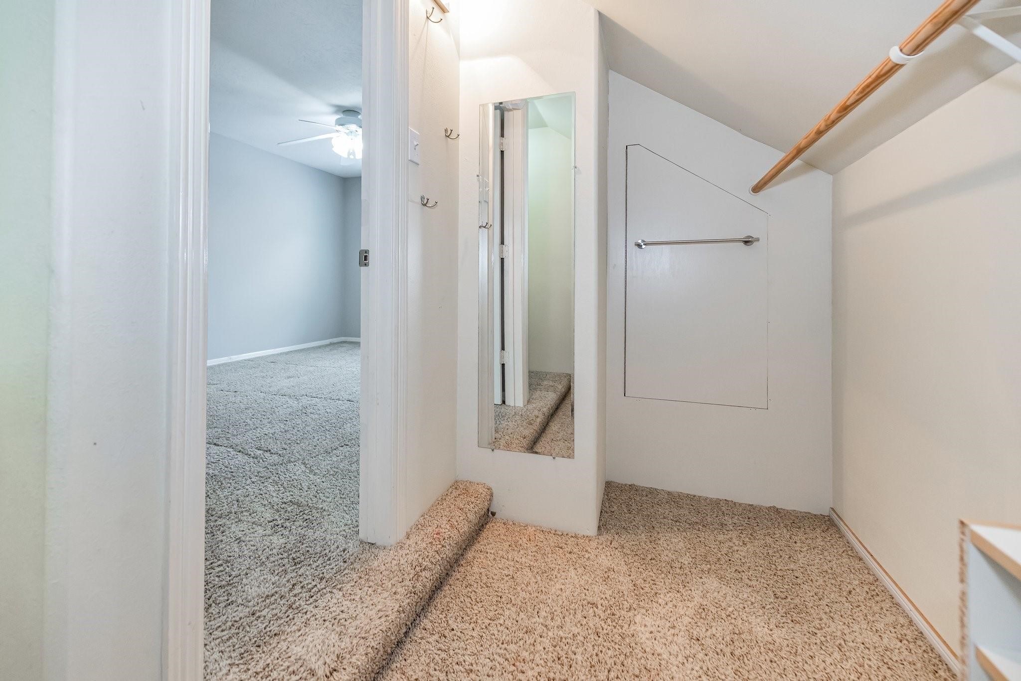 Third bedroom closet with dressing mirror and access to attic storage.