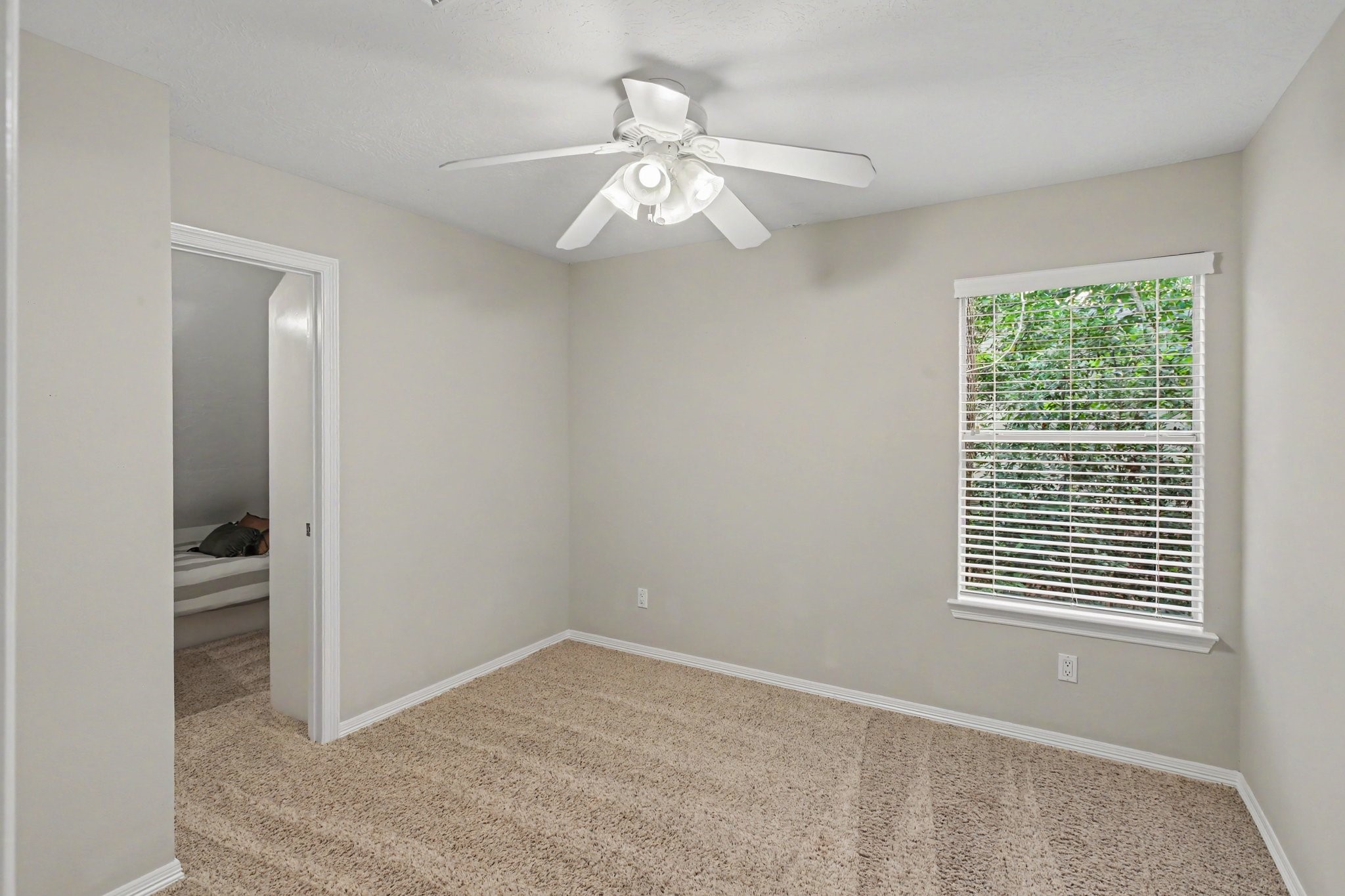 This secondary bedroom with carpet and ceiling fan has an amazing closet with a play/bunk room. Check out the next photo!