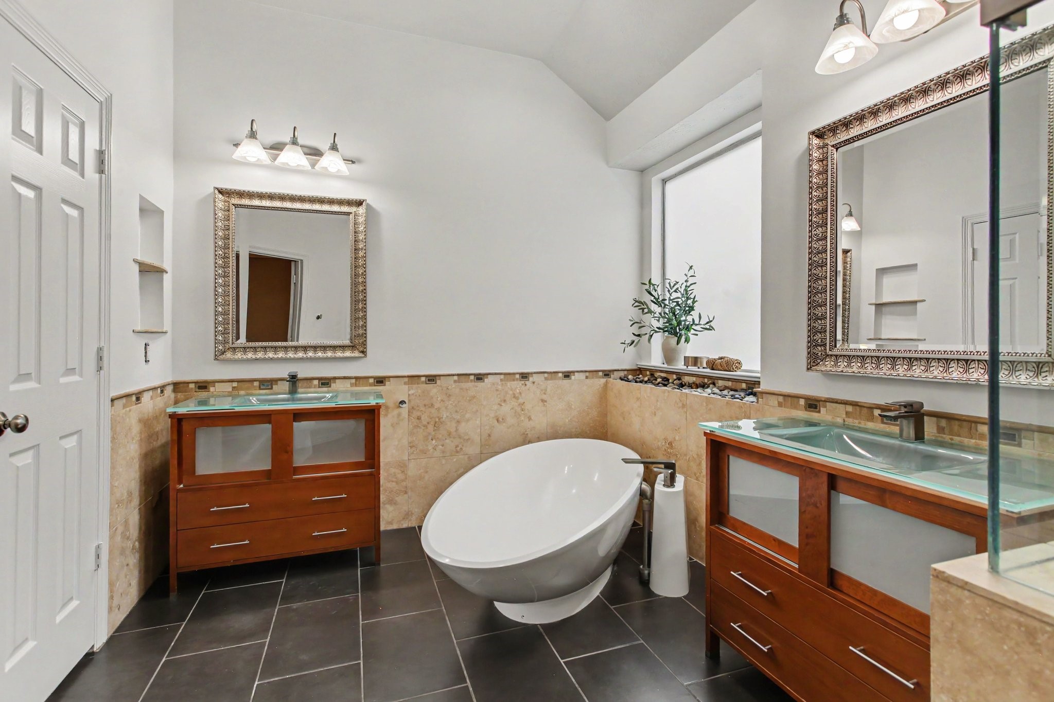 Modern ensuite bathroom inside the Owner's Suite, includes a private water closet, a large soaking tub and two vanities.