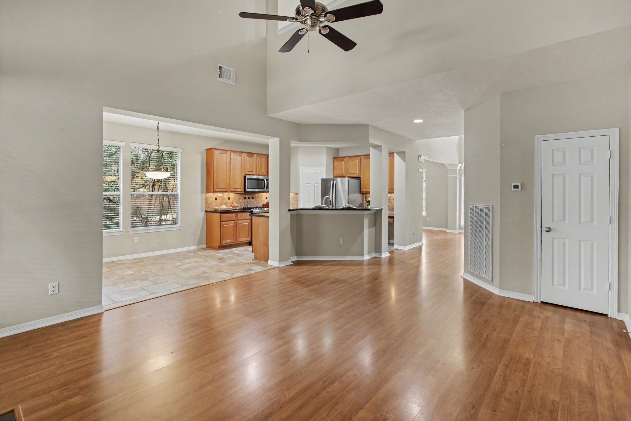 An additional view of the living room looking into the breakfast nook and kitchen with breakfast bar seating and a working desk inside the kitchen. The home has digital thermostats both up and down for your desired comfort.