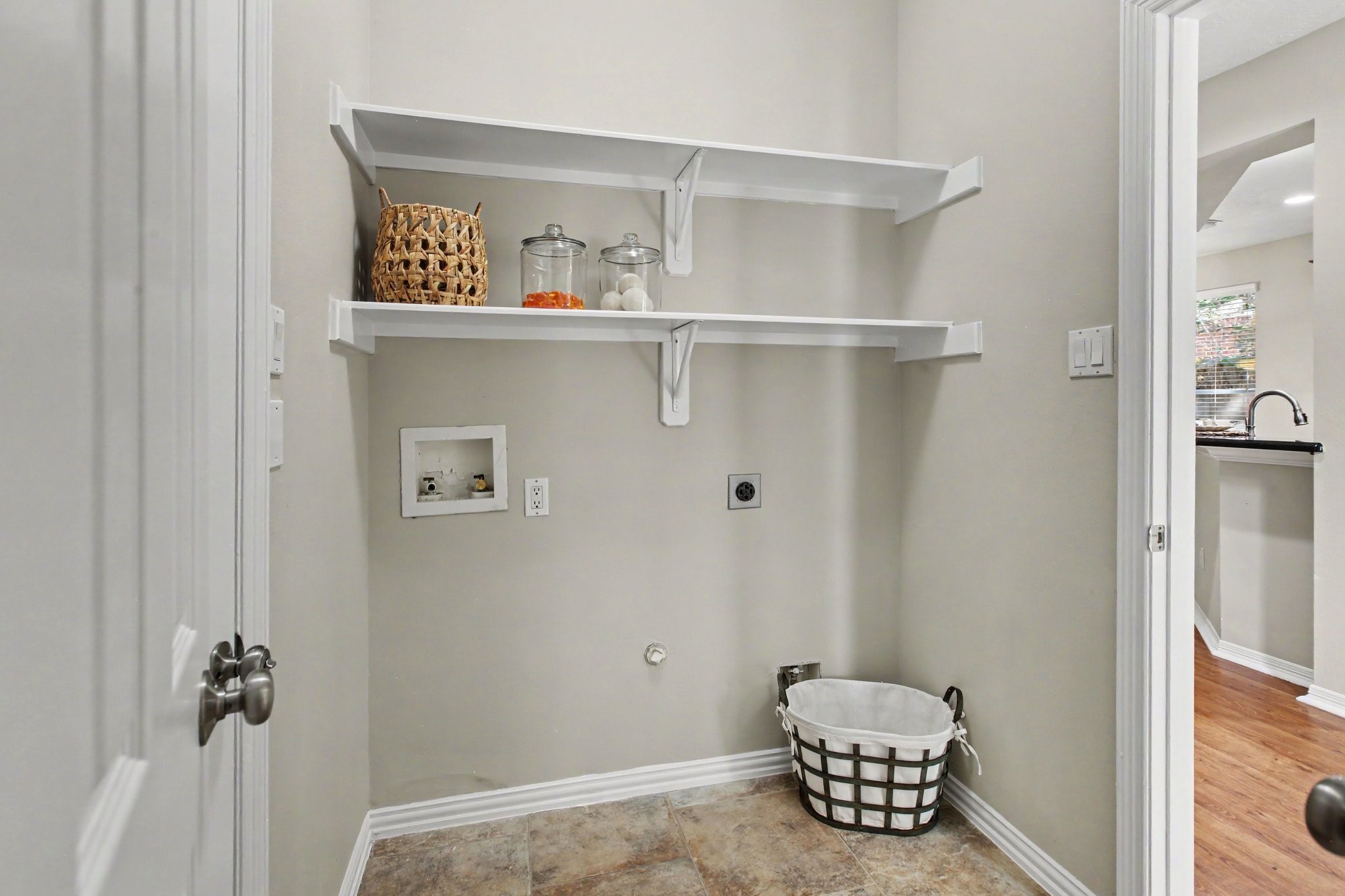 The laundry room is located downstairs with a access to the garage and has shelving and a fabulous under stair storage closet.