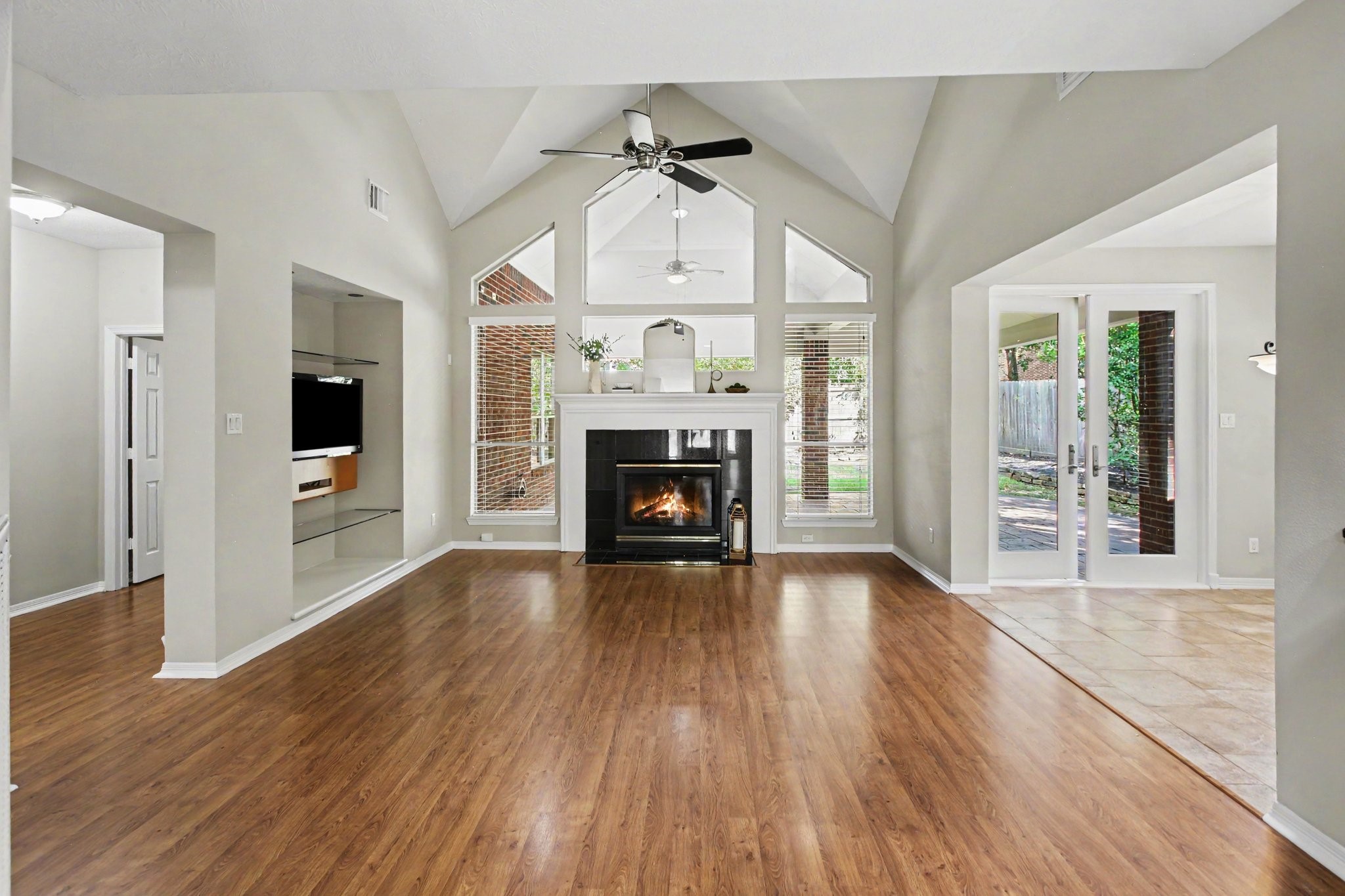 Gorgeous vaulted ceilings and natural light enhance the living room with beautiful, gleaming floors and a gaslog fireplace. The TV with mount is available to stay in the home.