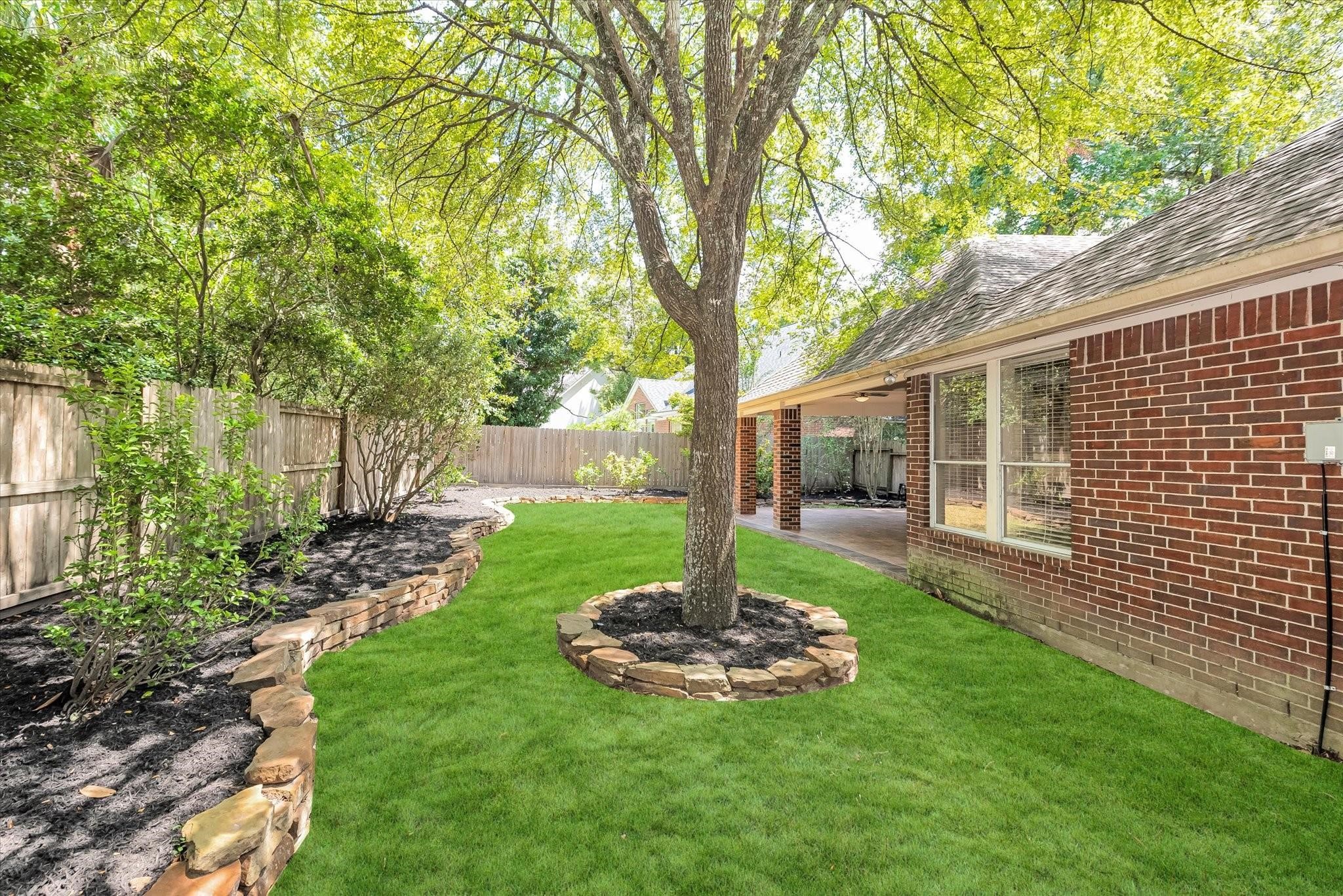 Private and peaceful ample backyard with freshly manicured landscaping and soaring trees.