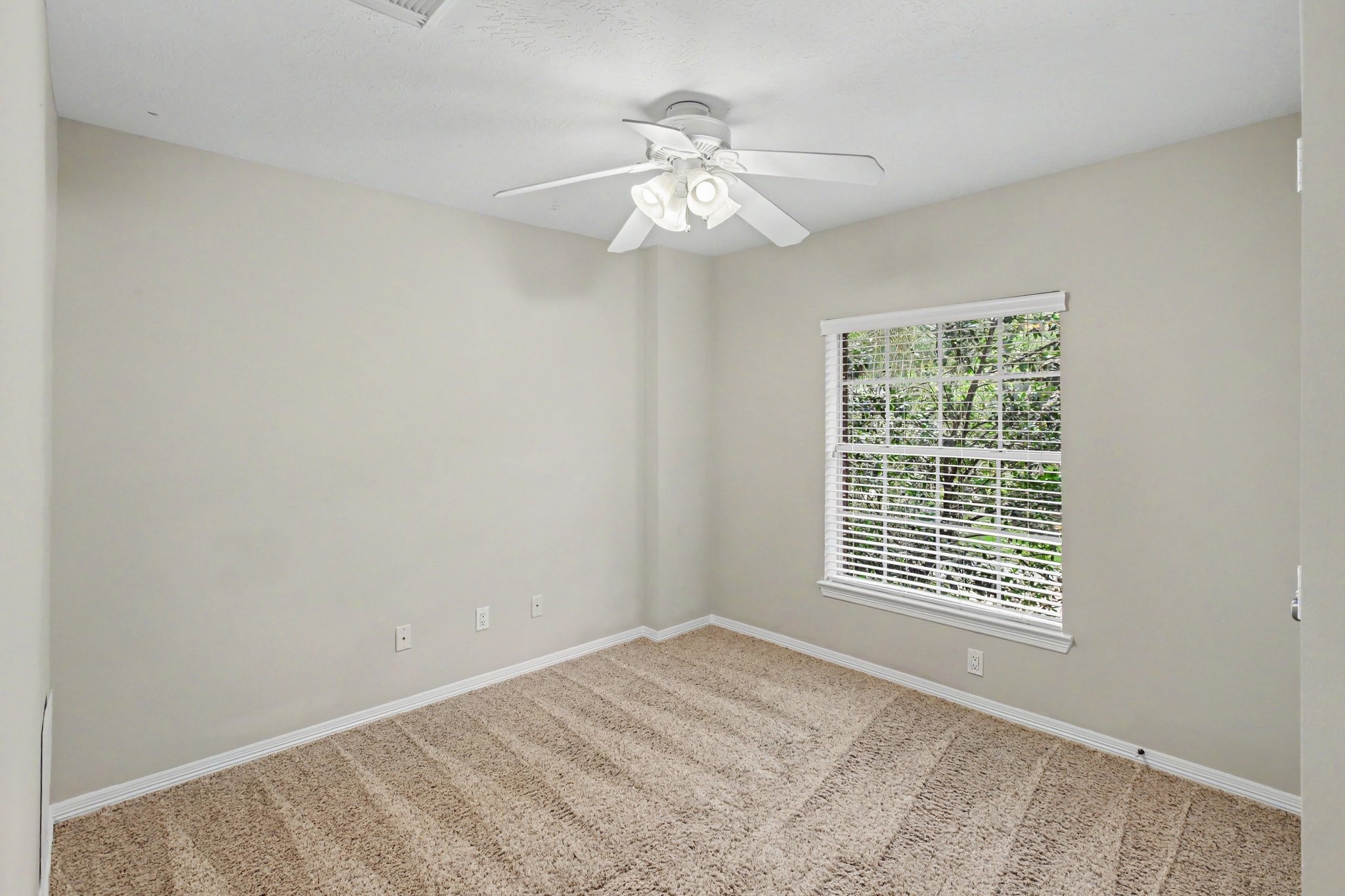 This secondary bedroom upstairs with comfy carpet and a full closet, sits at the front of the house.