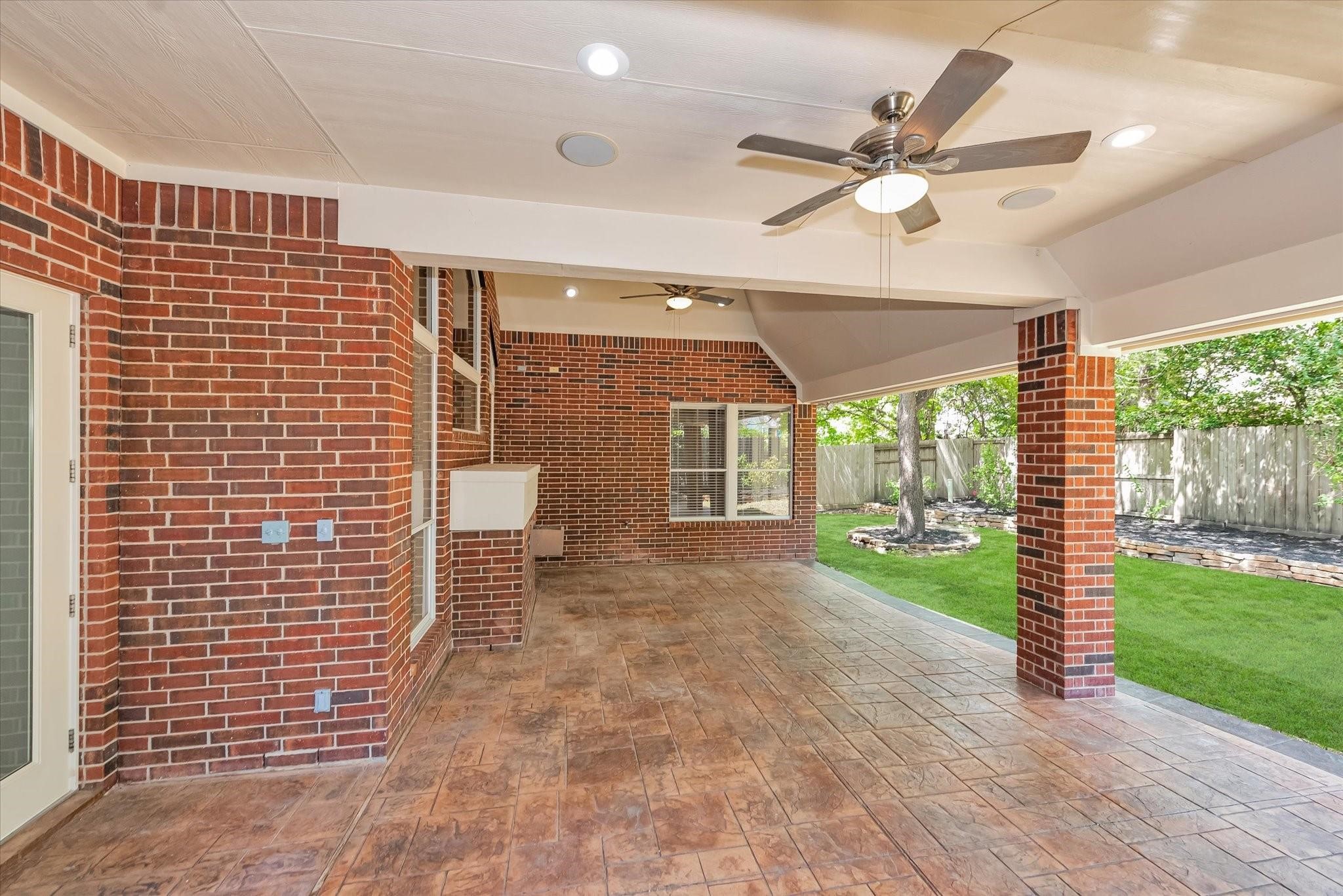 Side view of the covered back patio with two ceiling fans to cool you down during the summer heat and large areas perfect for an outdoor table and grill.