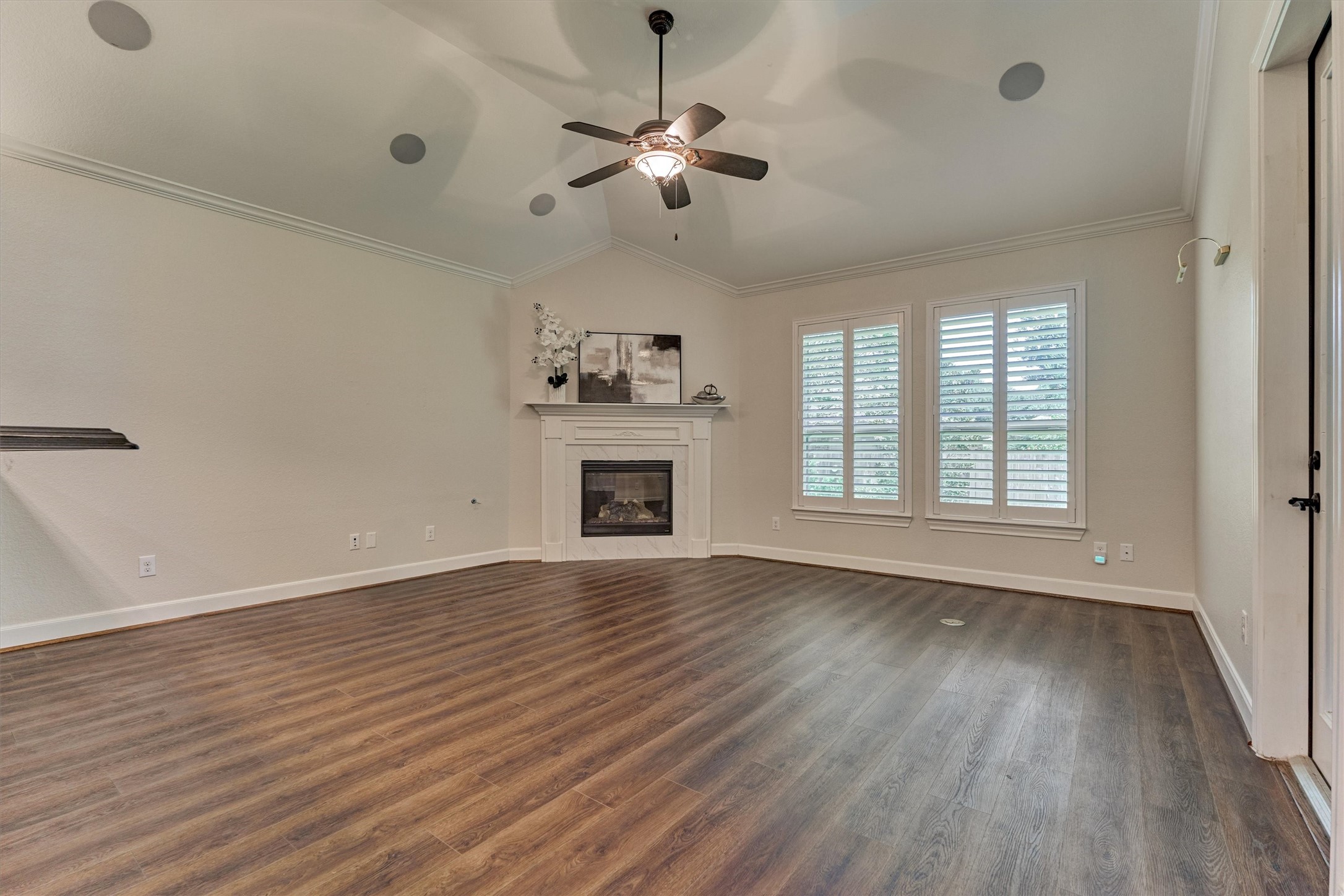 Den with cozy fireplace and windows overlooking the serene rear grounds.