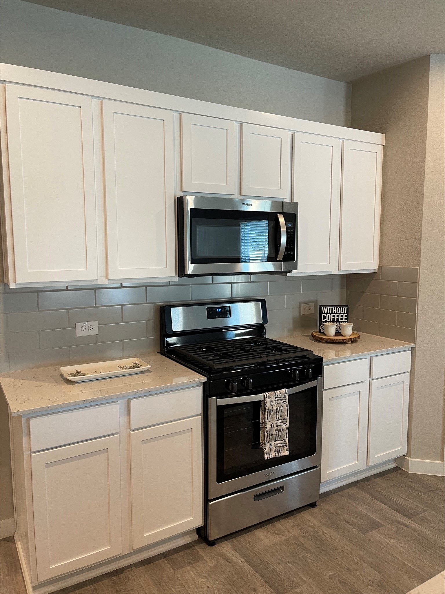 Modern kitchen with sleek stainless steel appliances, white cabinetry, and a stylish tile backsplash.