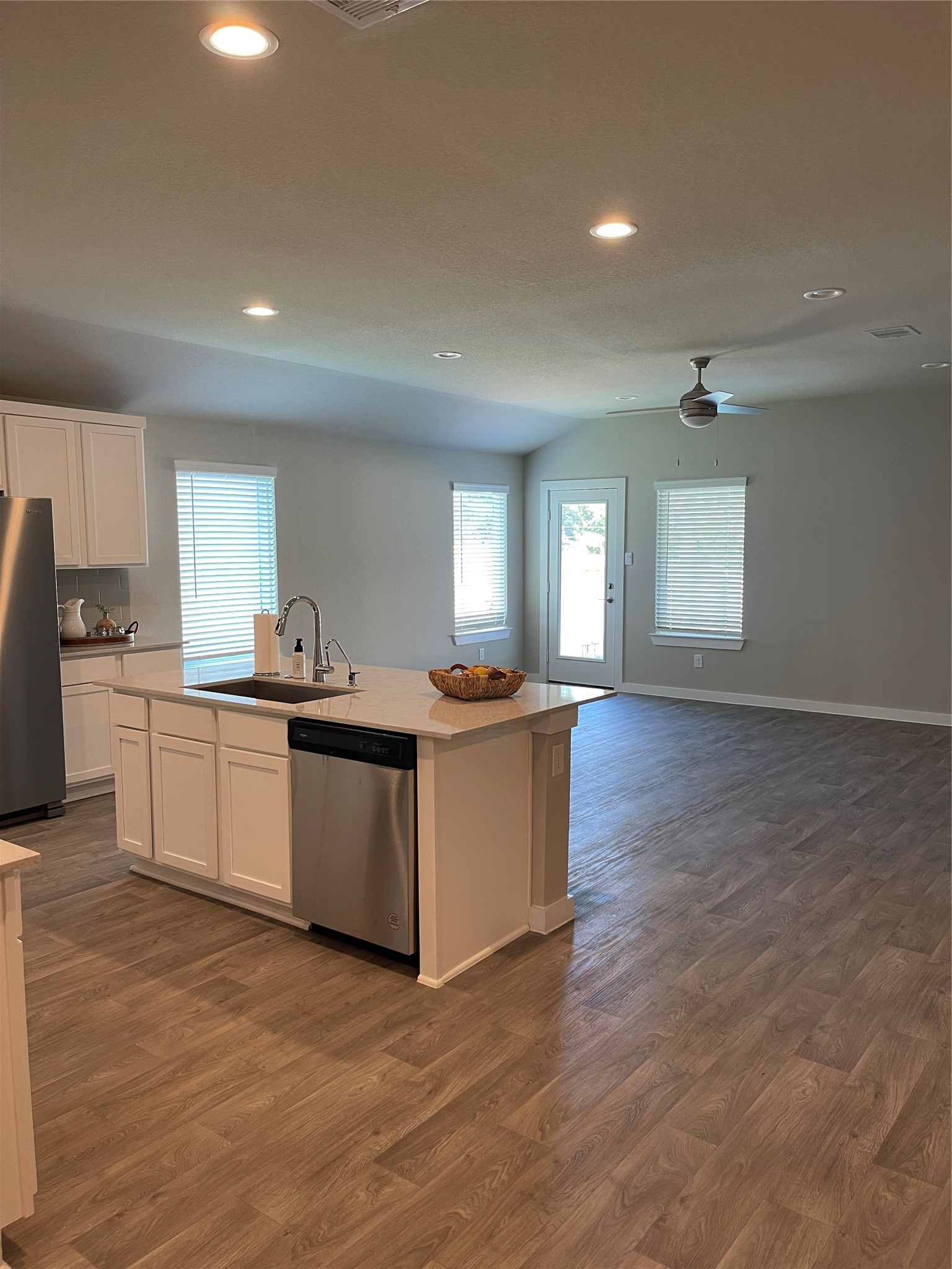 Spacious open-concept kitchen and living area featuring modern stainless steel appliances, and abundant natural light through large windows.