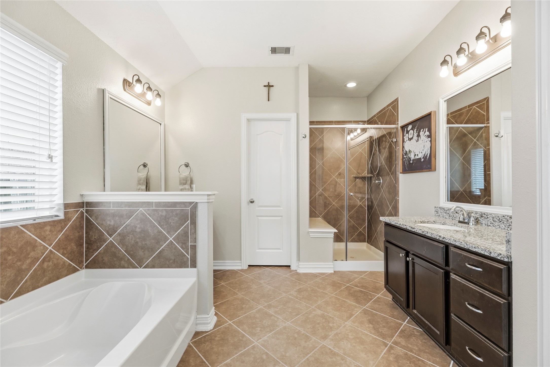The primary bathroom is complete with dual granite vanities, soaking tub, separate shower and walk-in closet.